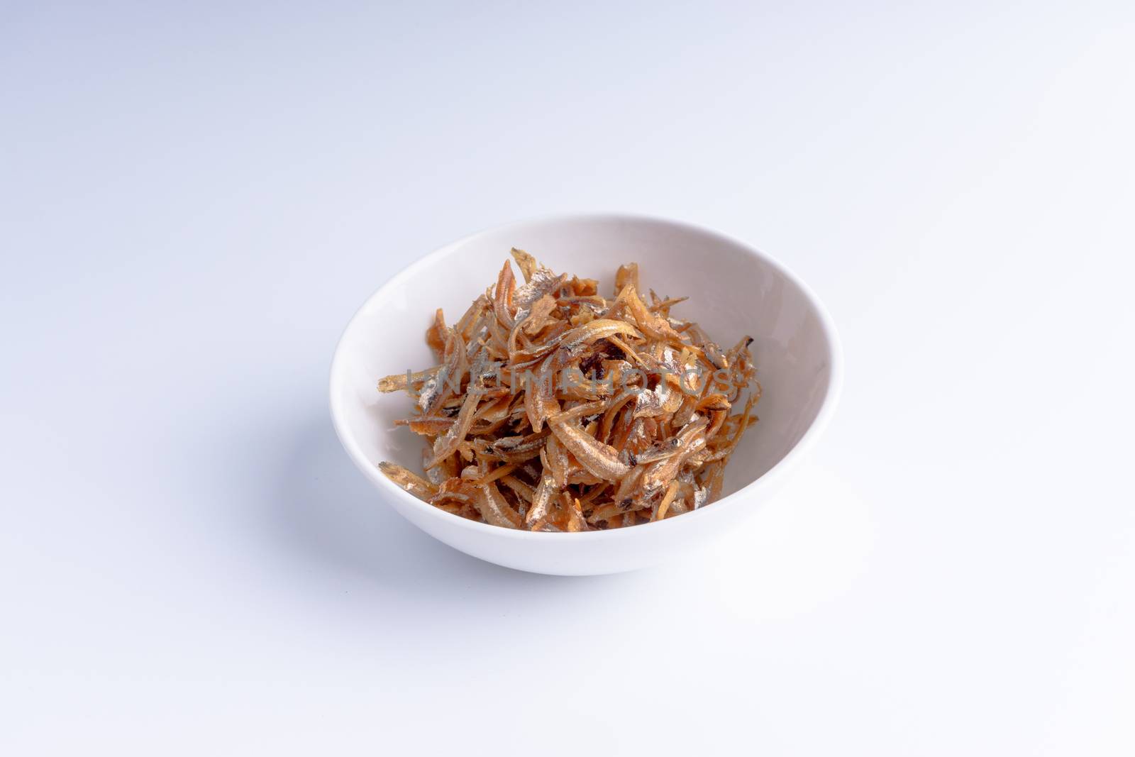 Fried anchovies in bowl close up by silverwings