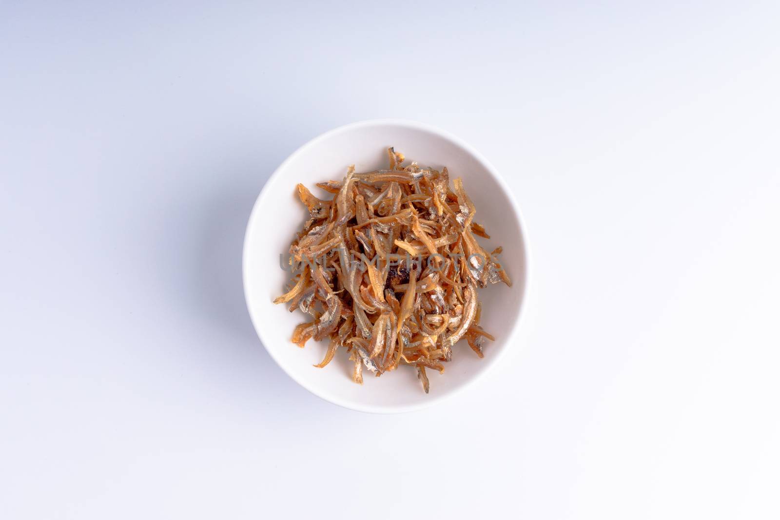 Fried anchovies in bowl close up with selective focus and crop fragment