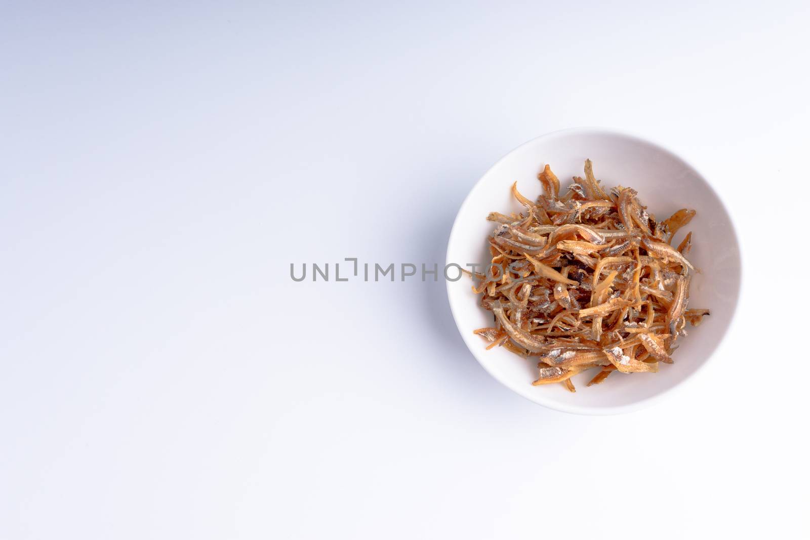 Fried anchovies in bowl close up by silverwings