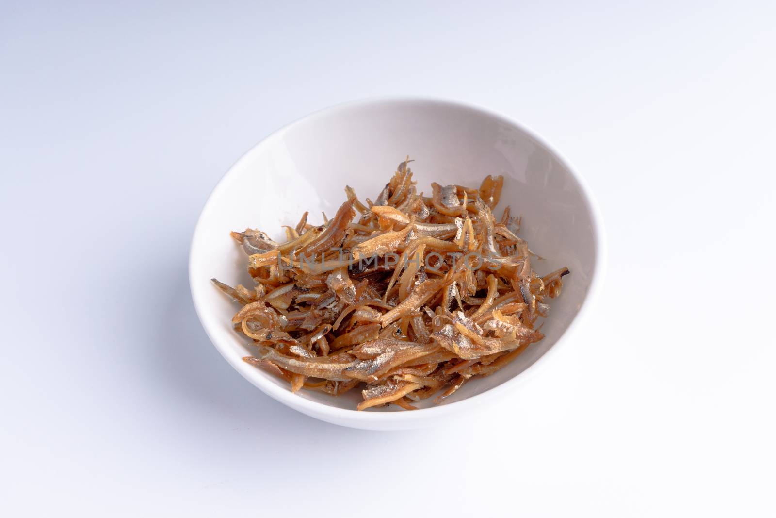 Fried anchovies in bowl close up with selective focus and crop fragment