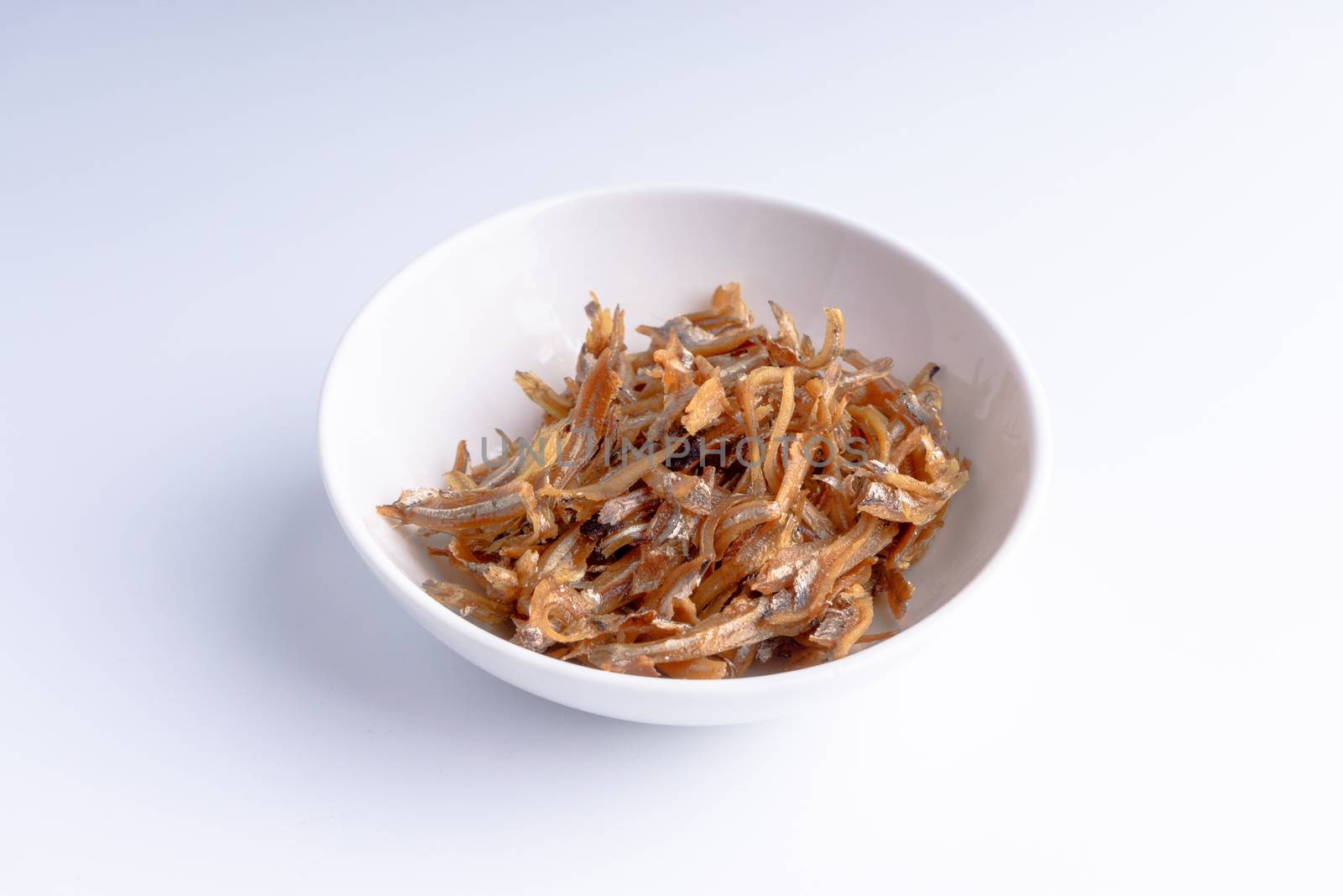 Fried anchovies in bowl close up by silverwings