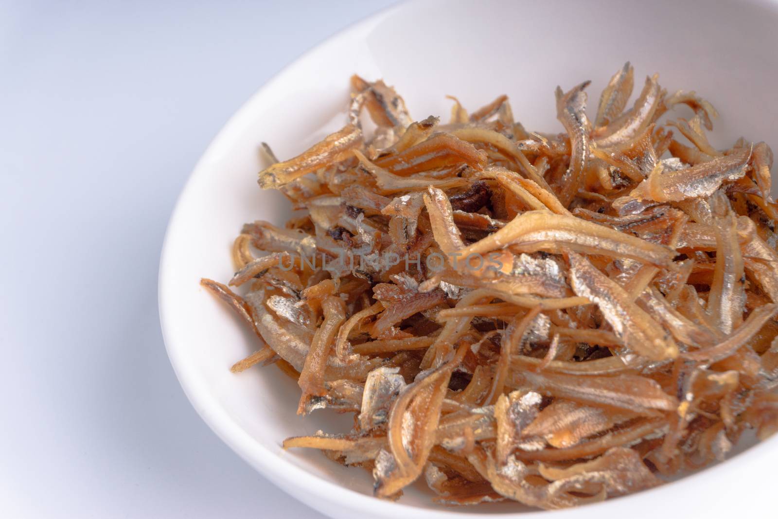 Fried anchovies in bowl close up by silverwings