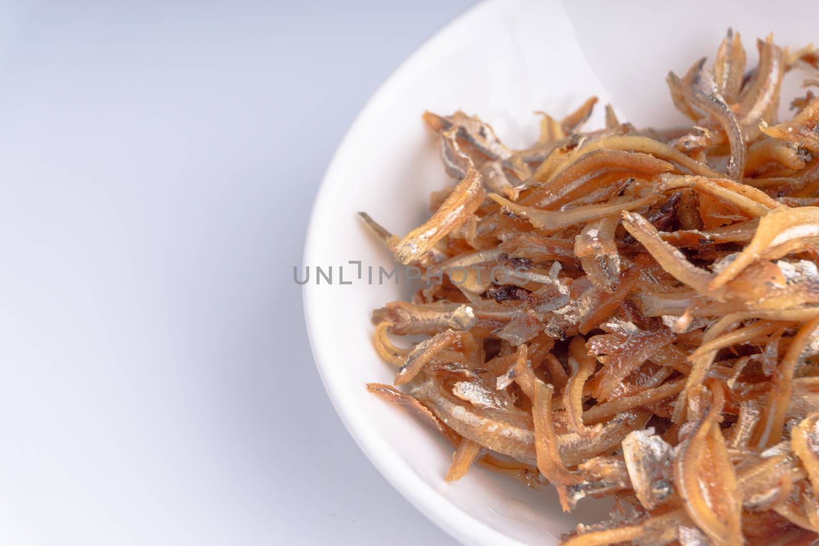 Fried anchovies in bowl close up by silverwings