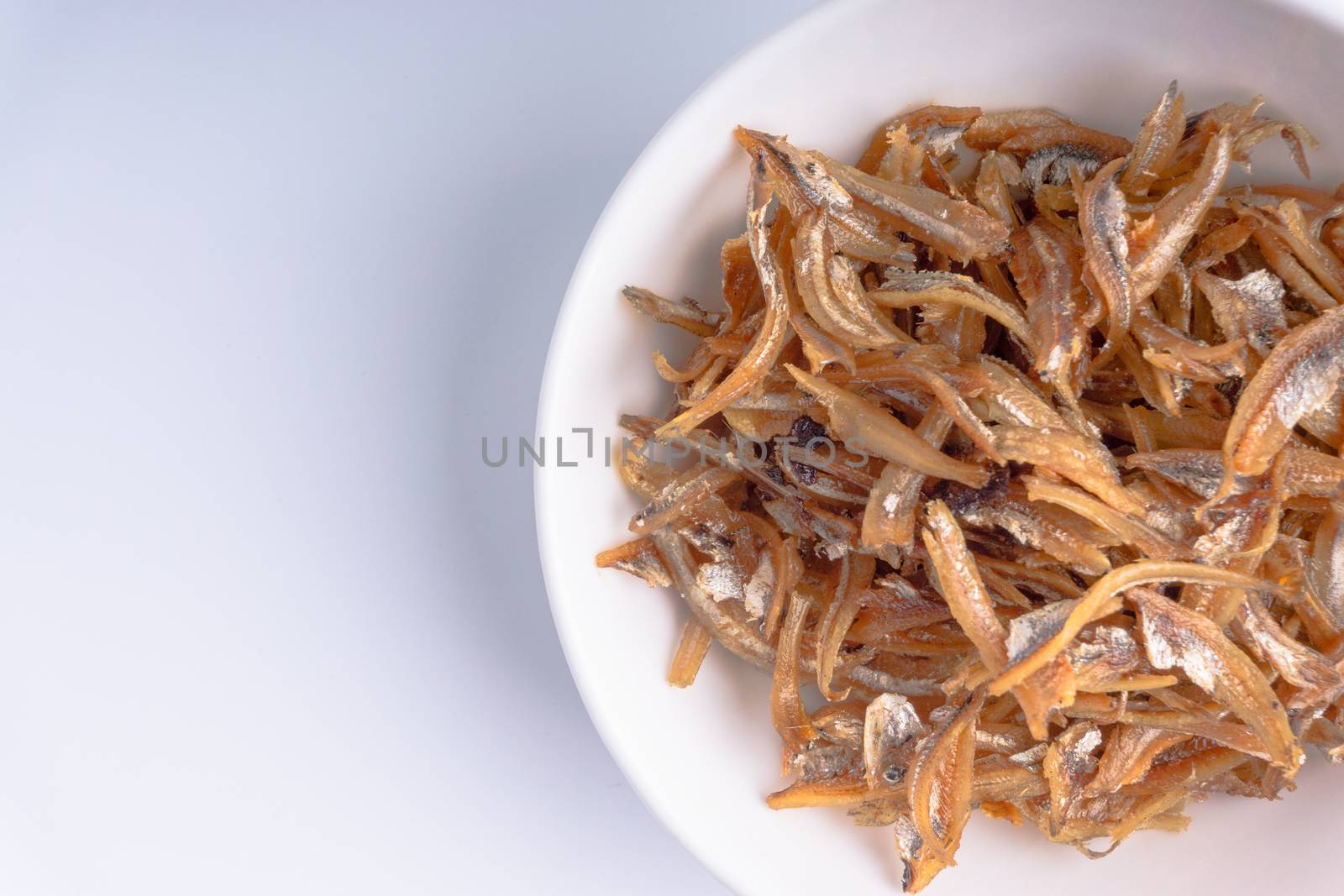 Fried anchovies in bowl close up by silverwings