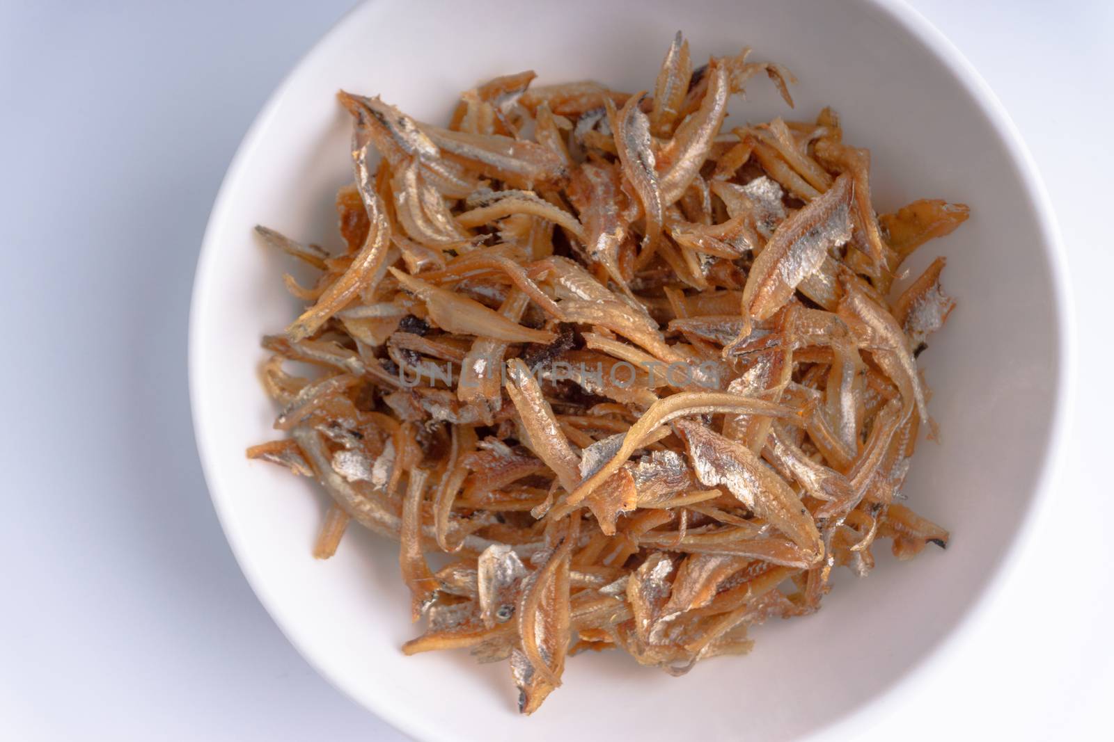 Fried anchovies in bowl close up by silverwings