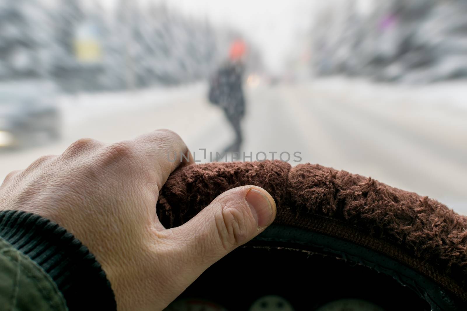 Emergency. A man's hand on the steering wheel of a car while braking against the background of a pedestrian suddenly appearing