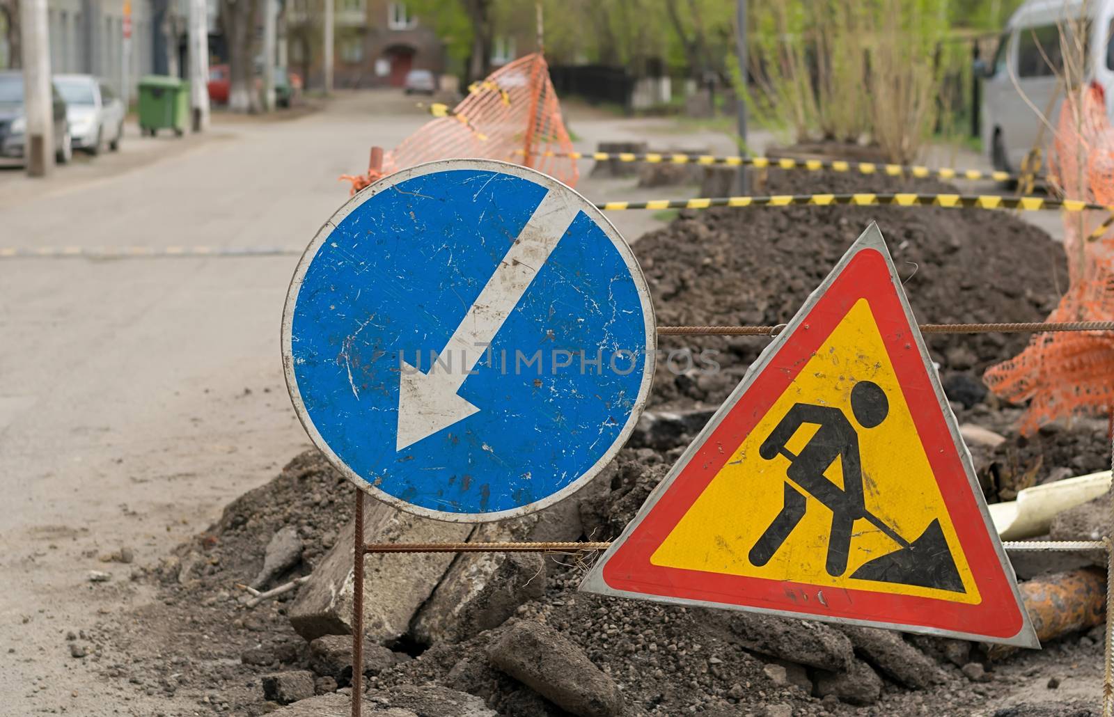 road sign, detour, road repair on the background of the road and broken asphalt covering on the urban street by jk3030