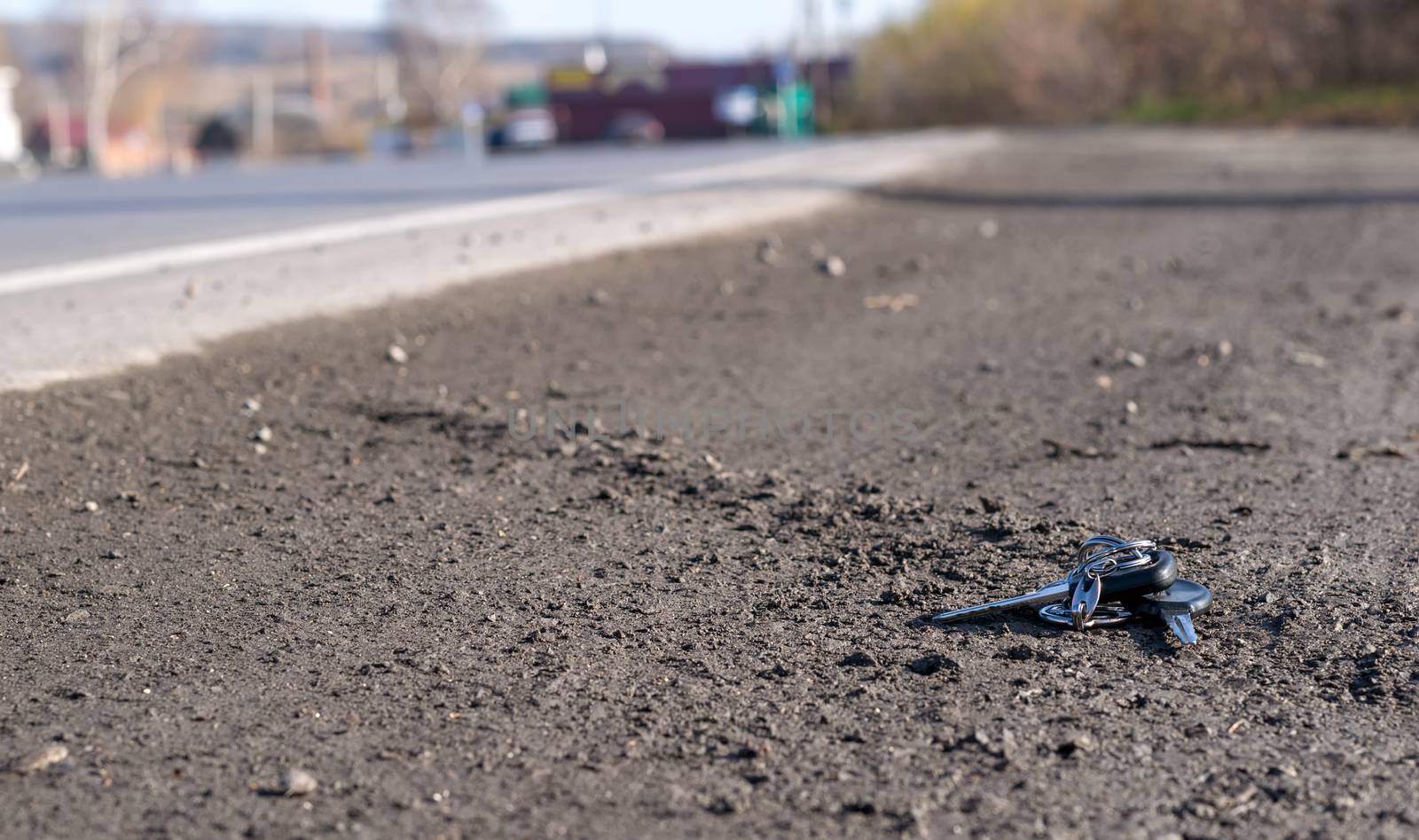 Lost bunch of keys lying on the side of the road near the asphalt pavement of the roadway