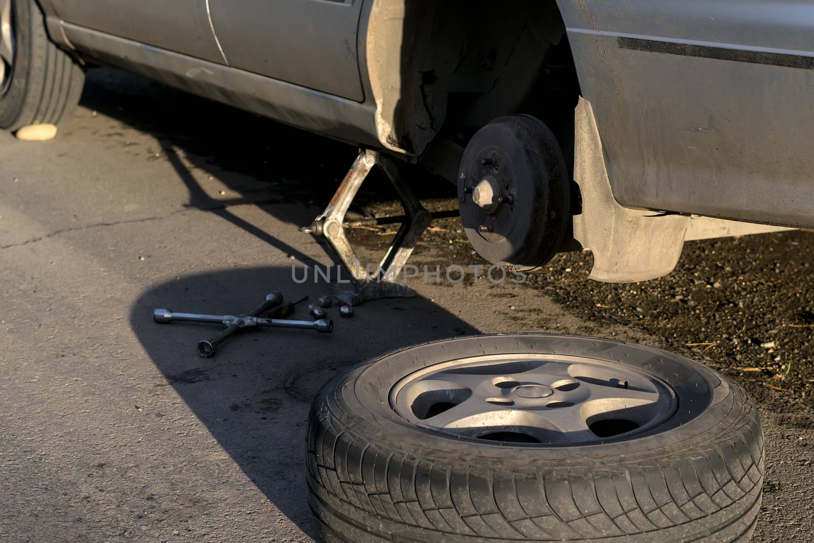 Replacing the rear wheel of the car. The car is mounted on the Jack by jk3030