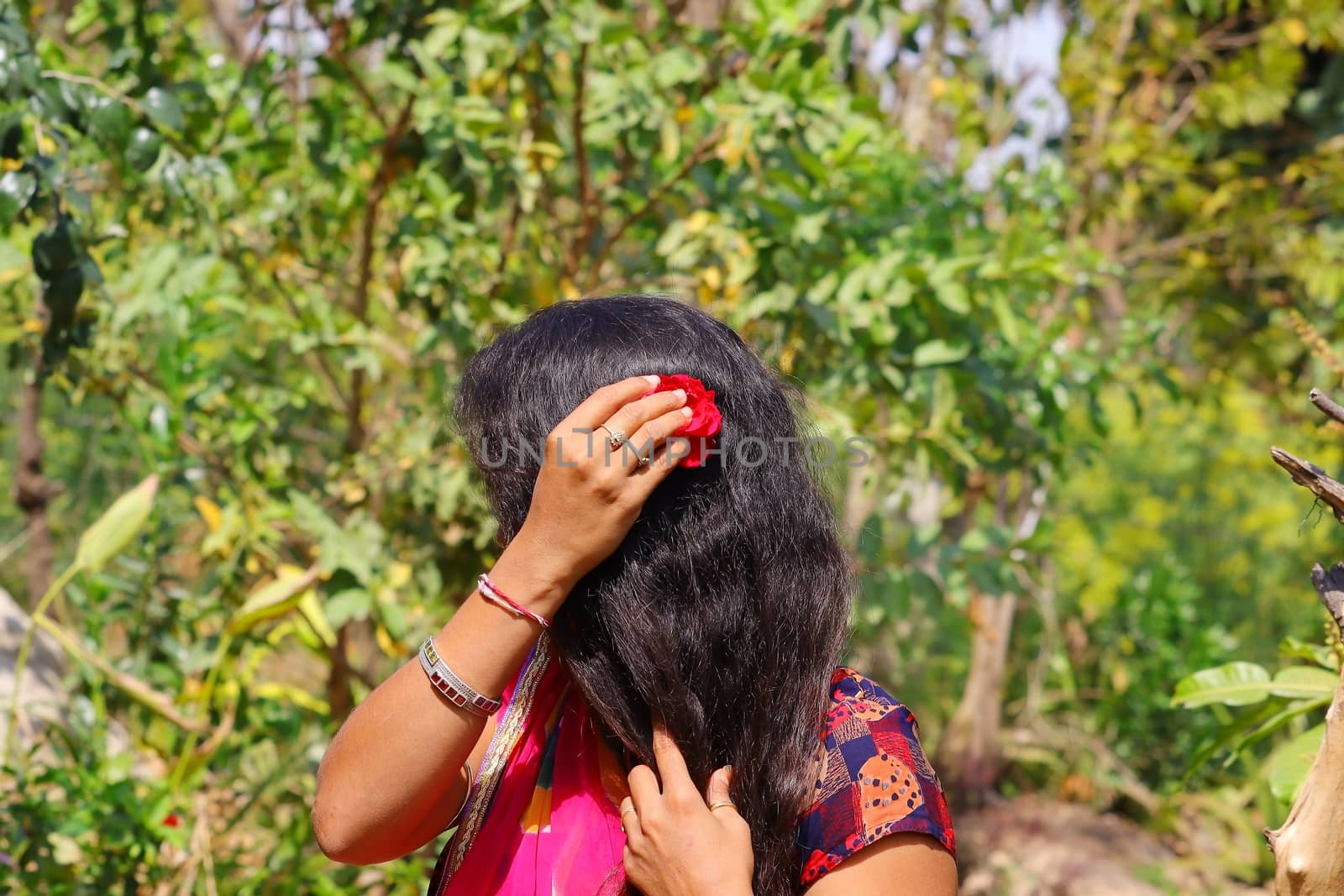 A young woman with a red rose flower in her hair