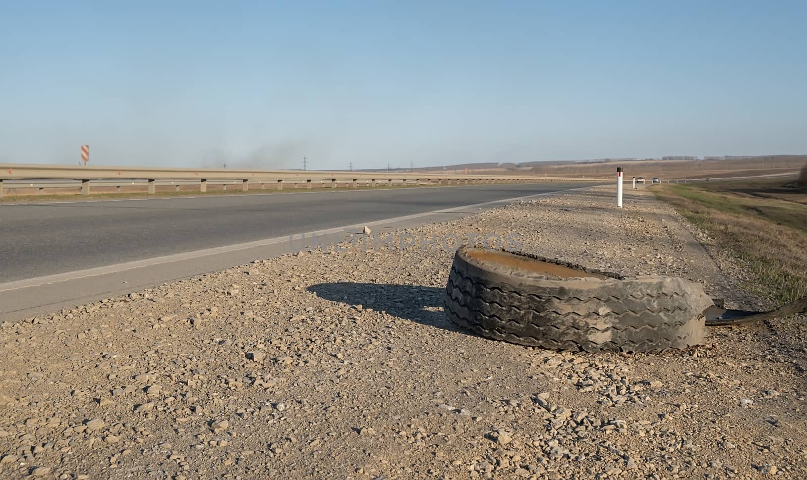 a torn car tire is lying on the side of the road