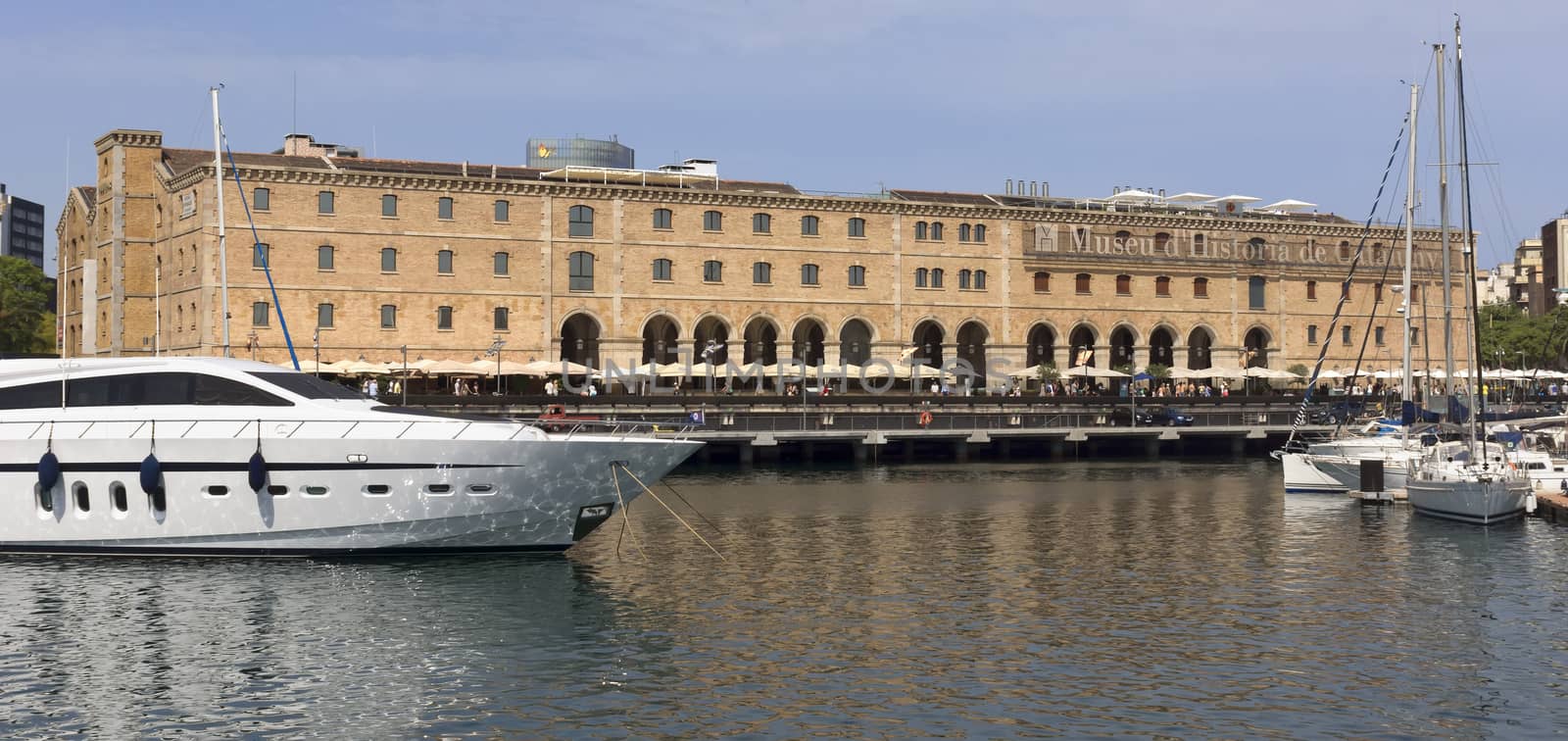 BARCELONA, SPAIN - JULY 4, 2015: The building "Palau de Mar" (1880-1890) home of museum "Museu d'Historia de Catalunya" in front of the harbor.

Barcelona, Spain - July 4, 2015: The building "Palau de Mar" (1880-1890) home of museum "Museu d'Historia de Catalunya" in front of the harbor. People walking at the promenade.