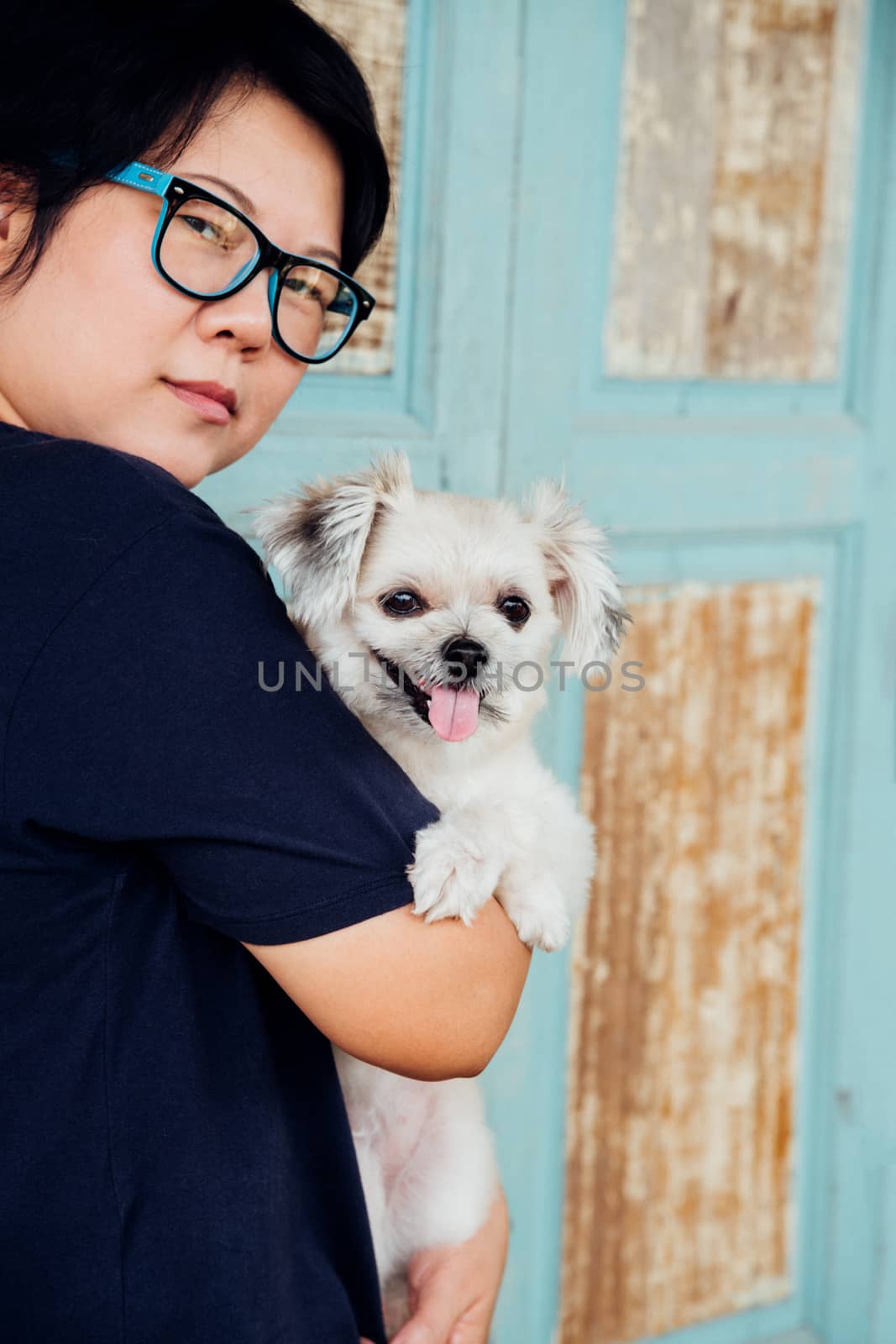 Asian woman hugging dog so cute with wooden wall by PongMoji