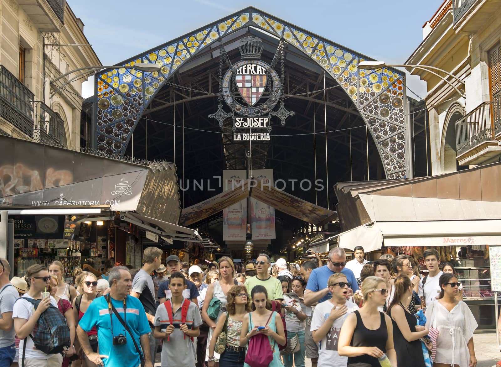 BARCELONA, SPAIN - JULY 6, 2015: Main gate at La Boqueria market. Market has been known since 1217. Now - one of the city's foremost tourist landmarks.

Barcelona, Spain - July 6, 2015: Main gate at La Boqueria market. Market has been known since 1217. Now - one of the city's foremost tourist landmarks. People near an entrance of market.