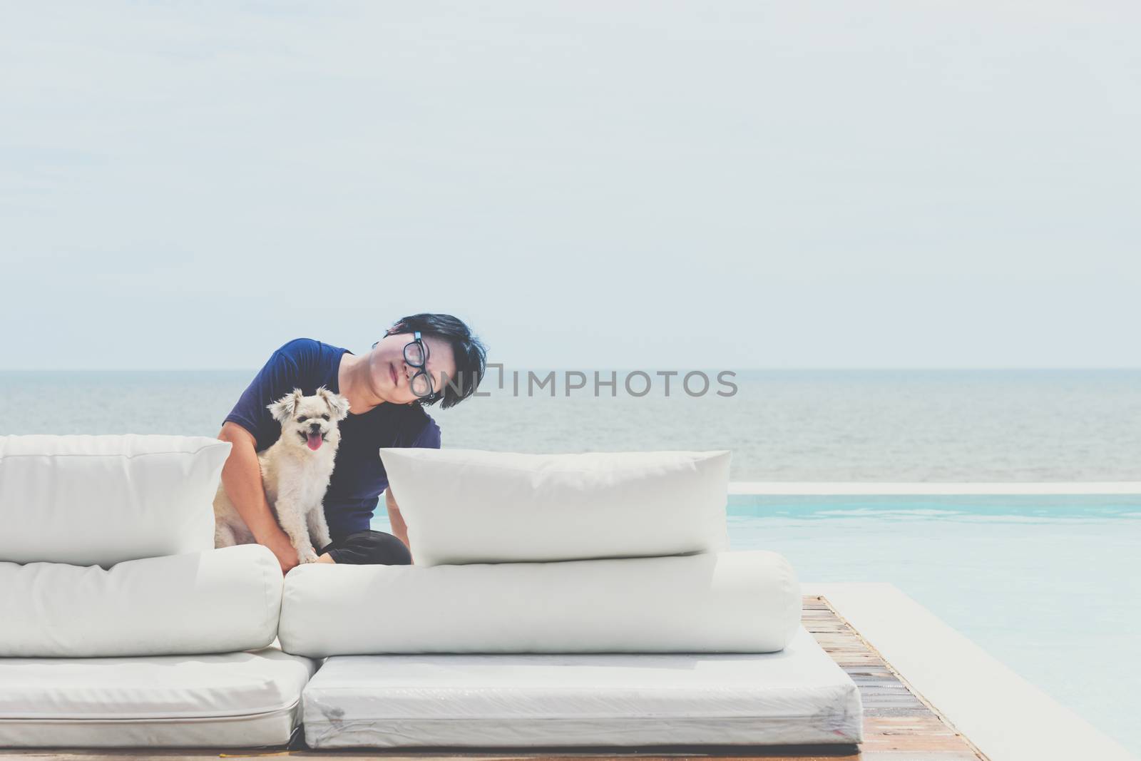 Woman and dog on white bed at pool seaside the sea by PongMoji