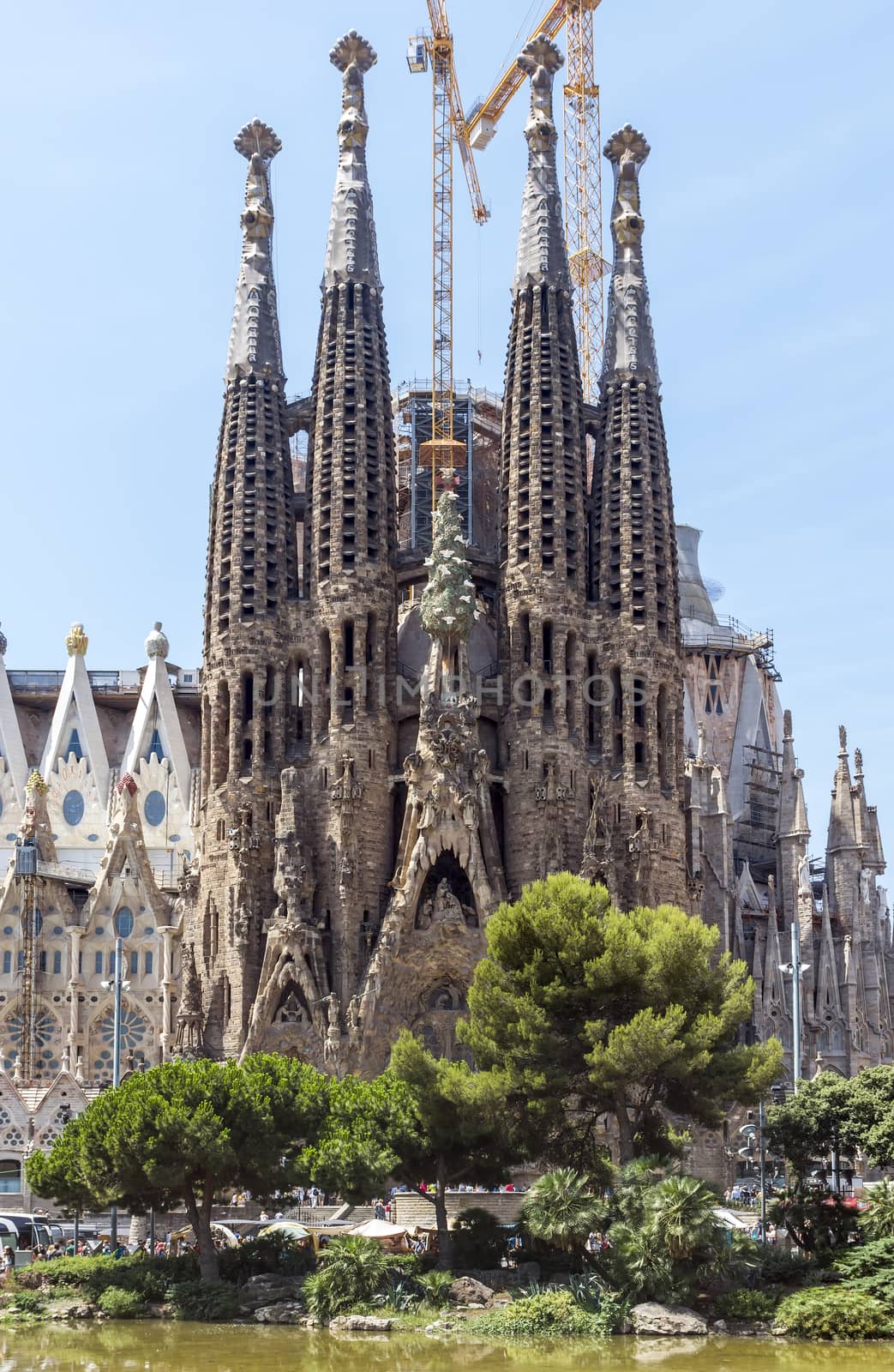 BARCELONA, SPAIN - JULY 6, 2015: La Sagrada Familia - the impressive cathedral designed by Gaudi, which is being build since 19 March 1882 and is not finished yet.

Barcelona, Spain - July 6, 2015: La Sagrada Familia - the impressive cathedral designed by Gaudi, which is being build since 19 March 1882 and is not finished yet. People are walking by street.