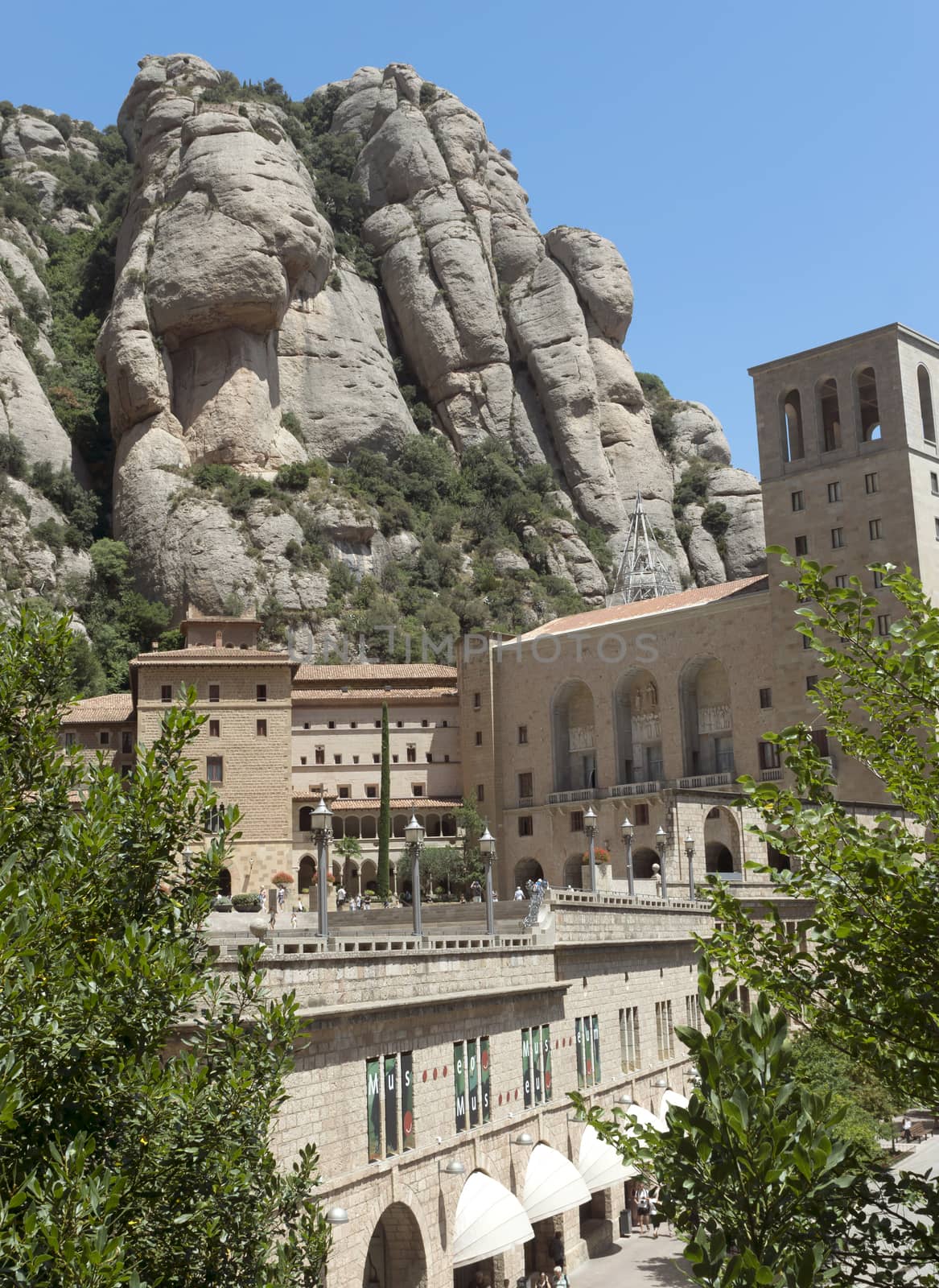 BARCELONA, SPAIN - JULY 10, 2015: The Benedictine abbey Santa Maria de Montserrat in Monistrol de Montserrat, Spain. It hosts the Virgin of Montserrat, the favourite in Catalonia.

Barcelona, Spain - July 10, 2015: The Benedictine abbey Santa Maria de Montserrat in Monistrol de Montserrat. It hosts the Virgin of Montserrat, the favourite in Catalonia. Montserrat Monastery located high up in the mountains near Barcelona, Spain. People are visiting the Monastery.