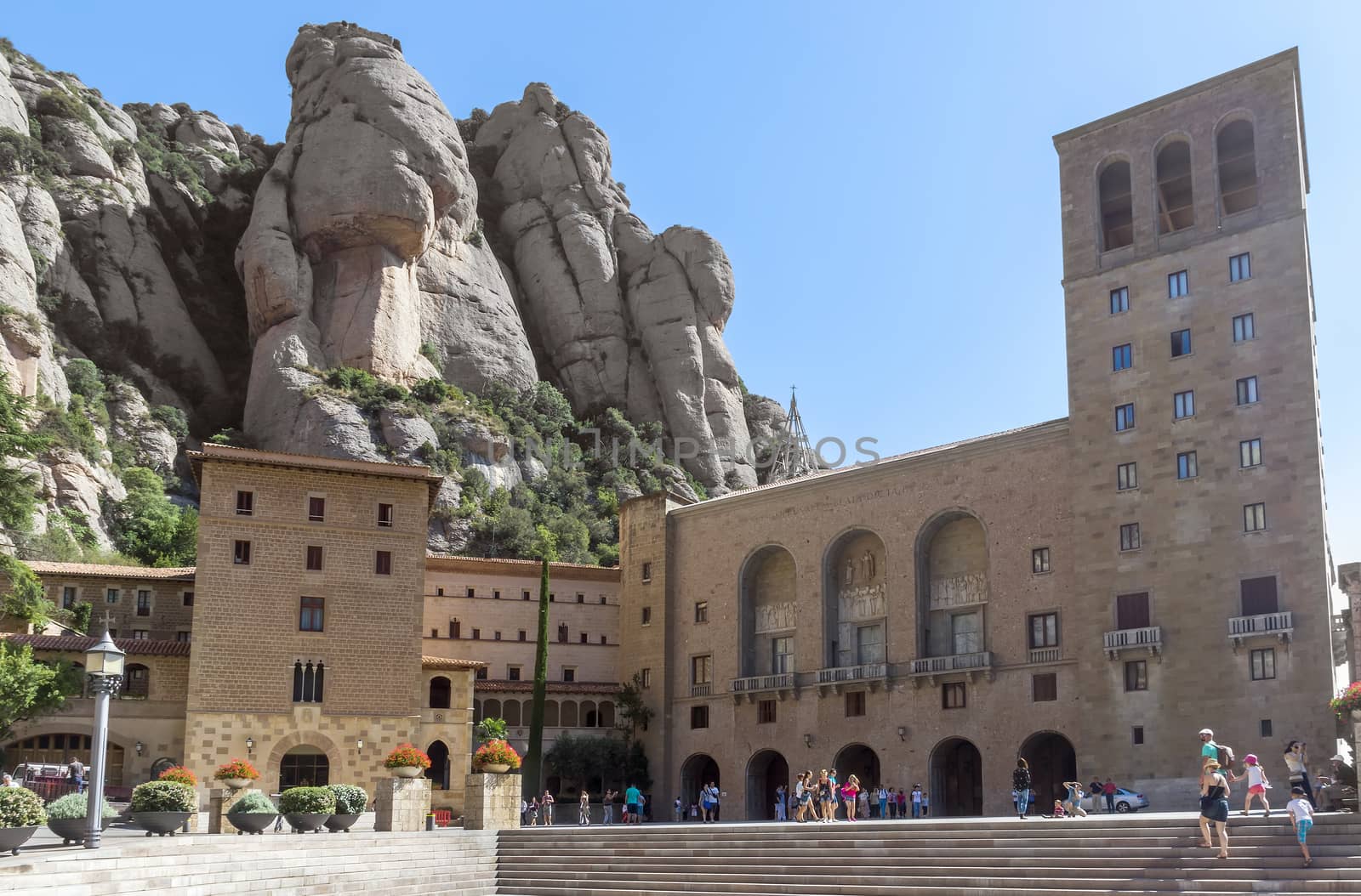 BARCELONA, SPAIN - JULY 10, 2015: The Benedictine abbey Santa Maria de Montserrat in Monistrol de Montserrat, Spain. It hosts the Virgin of Montserrat, the favourite in Catalonia.

Barcelona, Spain - July 10, 2015: The Benedictine abbey Santa Maria de Montserrat in Monistrol de Montserrat. It hosts the Virgin of Montserrat, the favourite in Catalonia. Montserrat Monastery located high up in the mountains near Barcelona, Spain. People are visiting the Monastery.