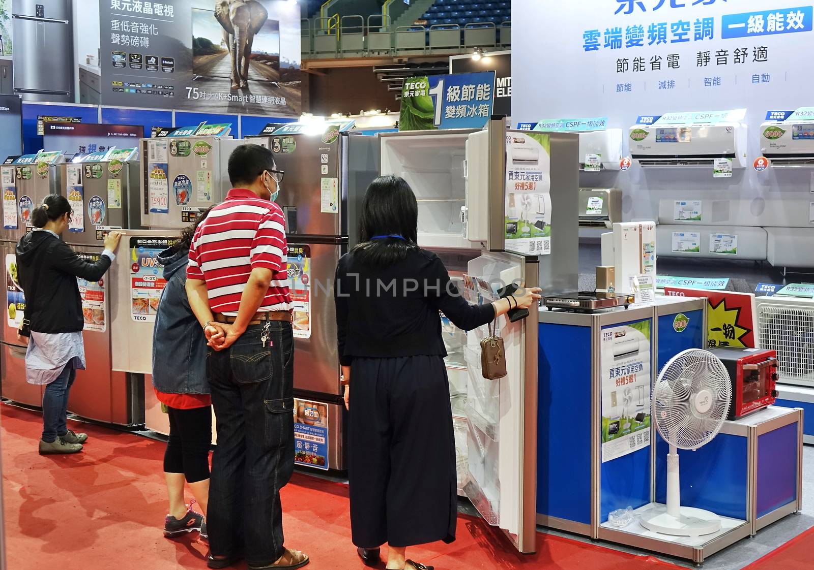 KAOHSIUNG, TAIWAN -- APRIL 5, 2019: Visitors at a sales and promotional fair for electric household appliances look at refrigerators.