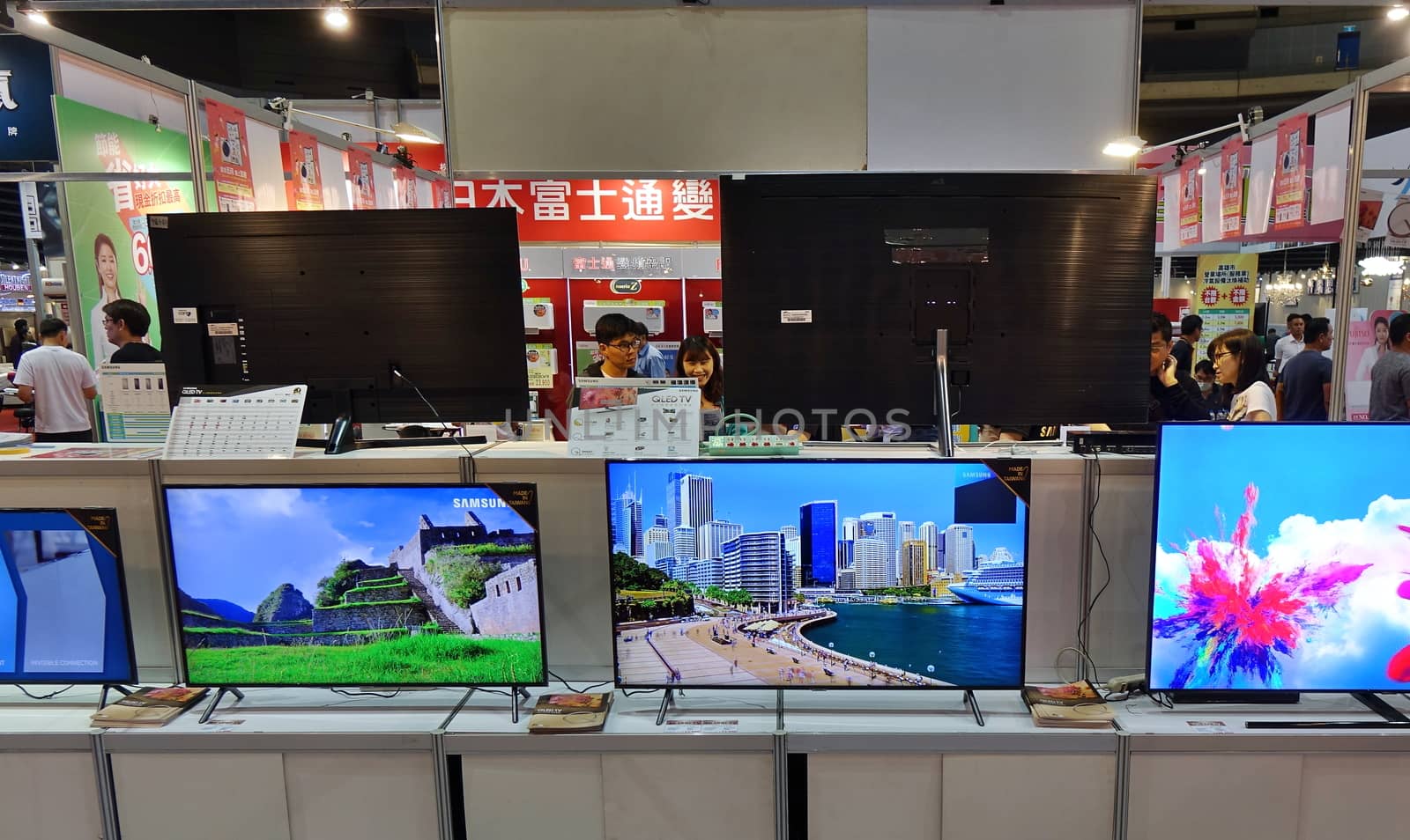 KAOHSIUNG, TAIWAN -- APRIL 5, 2019: Visitors at a sales and promotional fair for electric household appliances look at flat screen TVs.