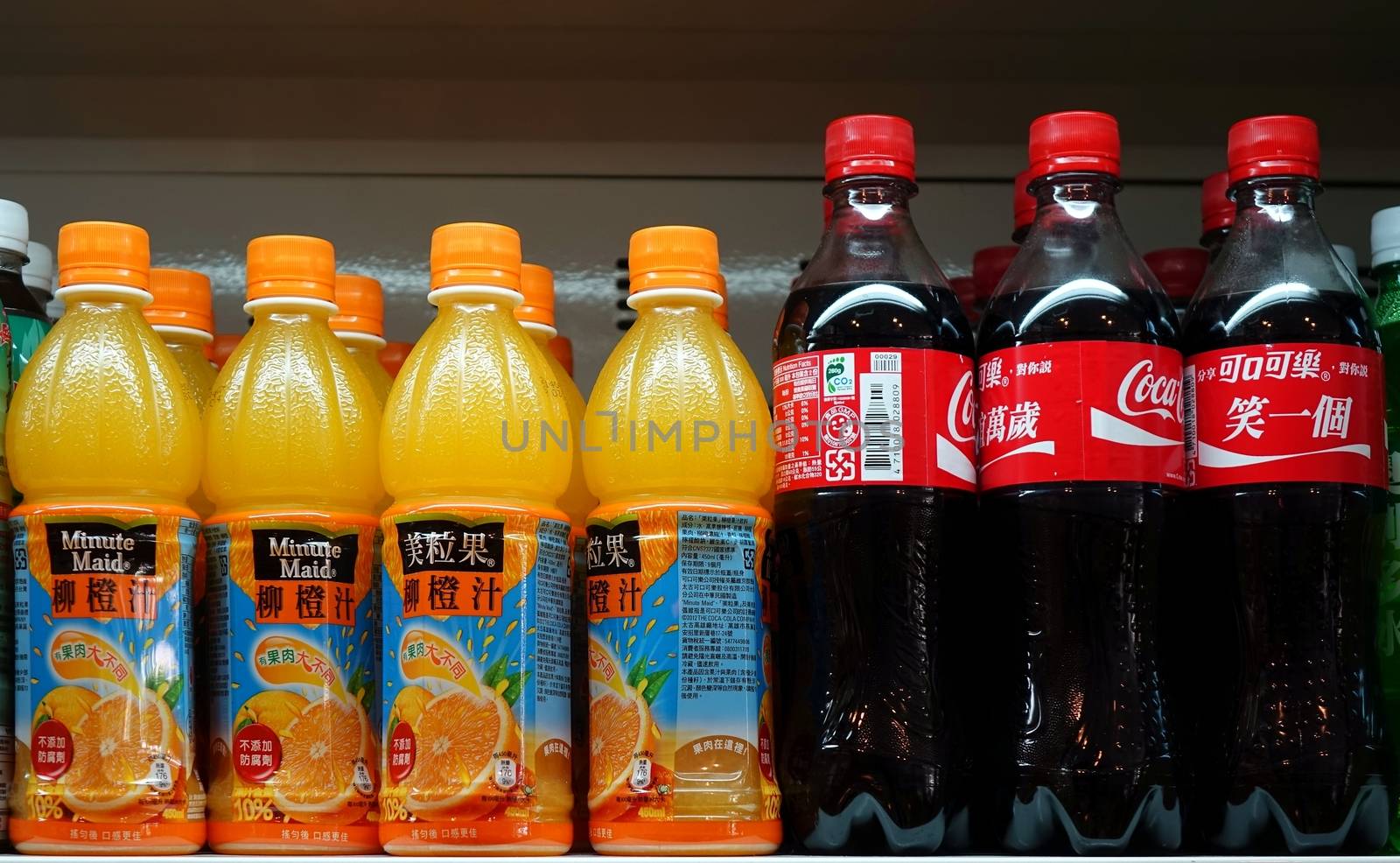KAOHSIUNG, TAIWAN -- MARCH 14, 2014: A stall selling cold drinks displays Minute Maid orange drinks and Coca Cola bottles on its shelf.