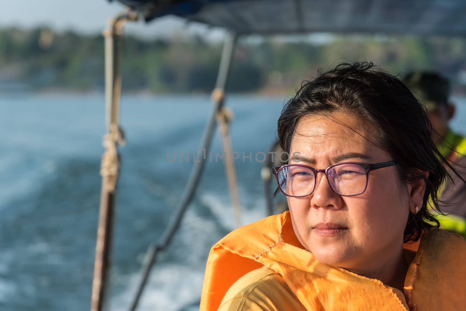 Asian woman sailing on Songkaria river by long tail boat with sun light in evening time when vacation travel for relax