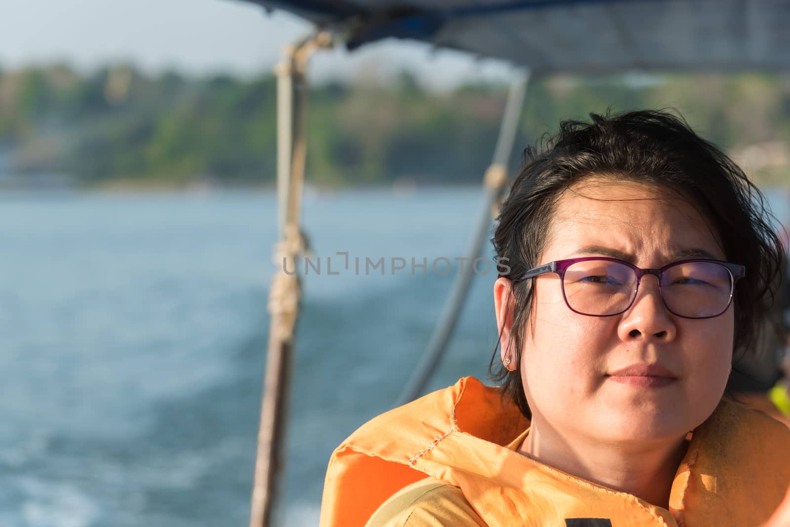 Asian woman sailing on Songkaria river by long tail boat with sun light in evening time when vacation travel for relax