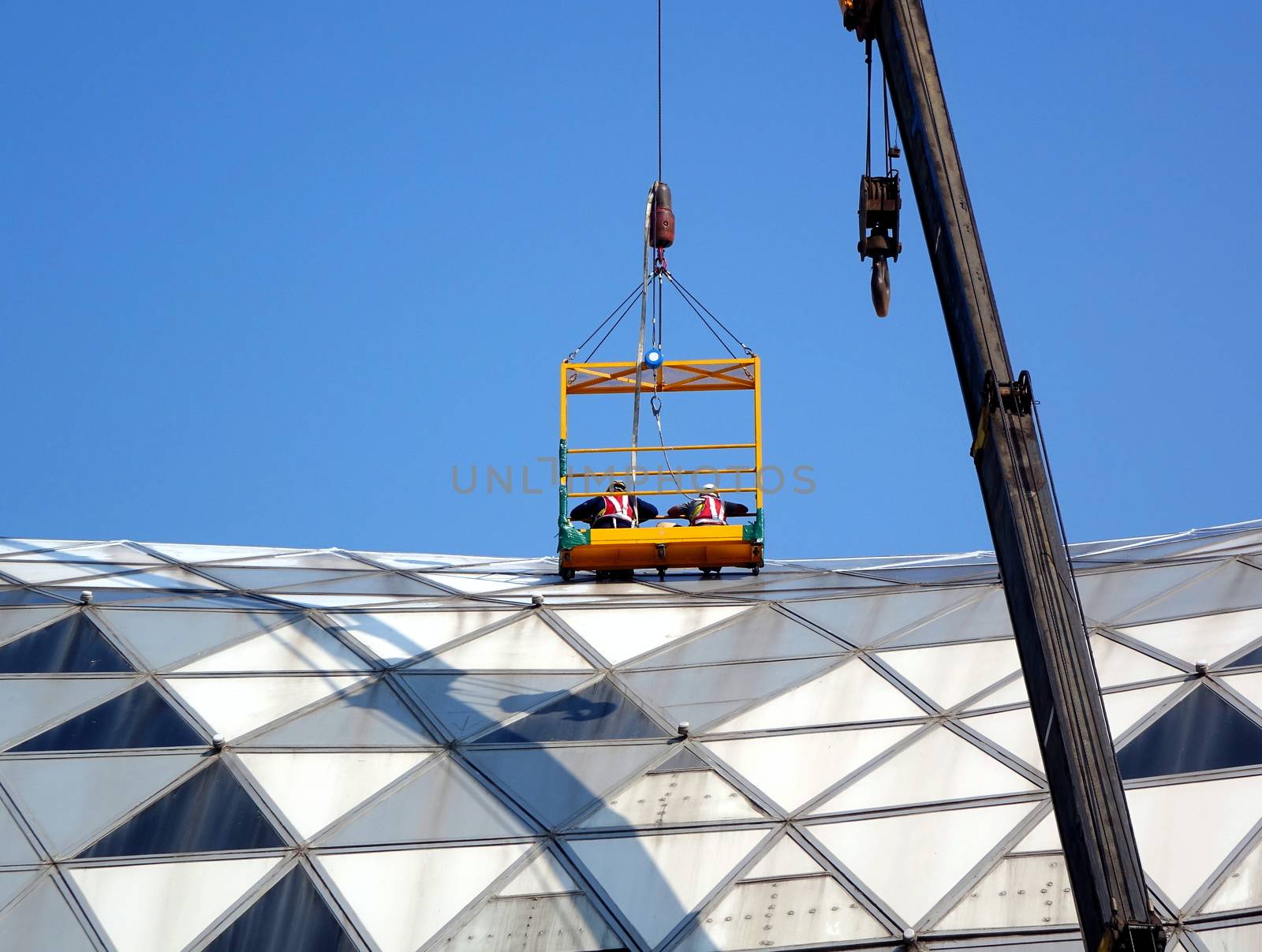 Workers Inspect the Roof of a Large Building by shiyali