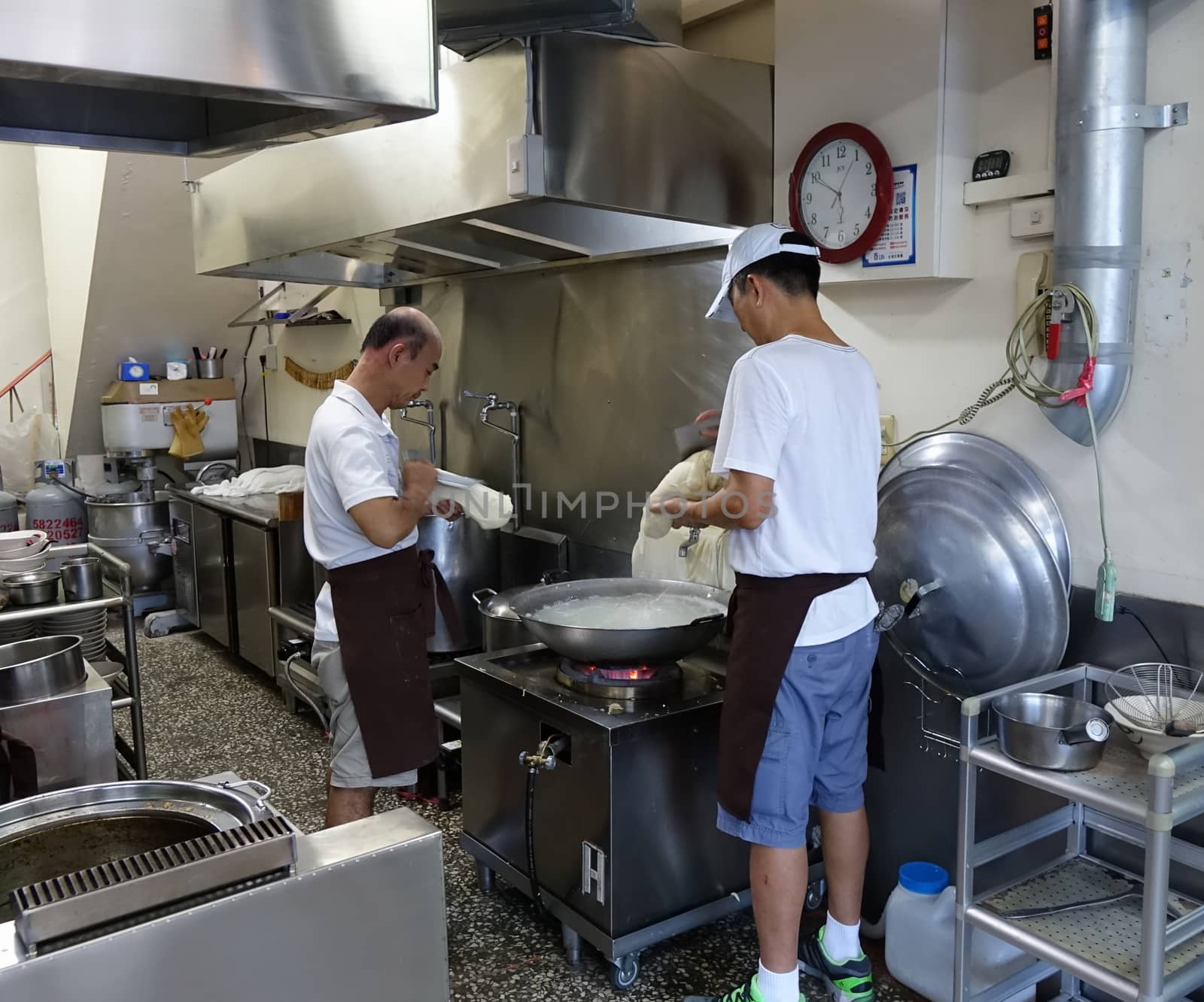 KAOHSIUNG, TAIWAN -- JULY 24, 2016: Two cooks prepare knife-cut noodles, a traditional dish from north-western China.
