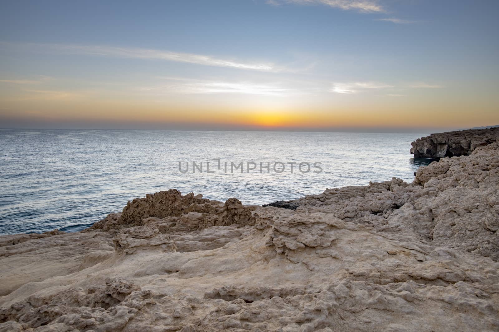 Sunset over the sea and the wild coast of the Sultanate of Oman