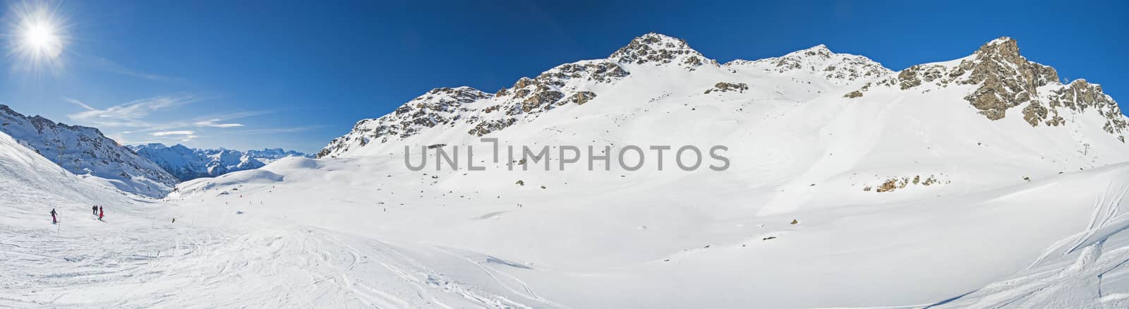 Panoramic view down snow covered valley in alpine mountain range by paulvinten