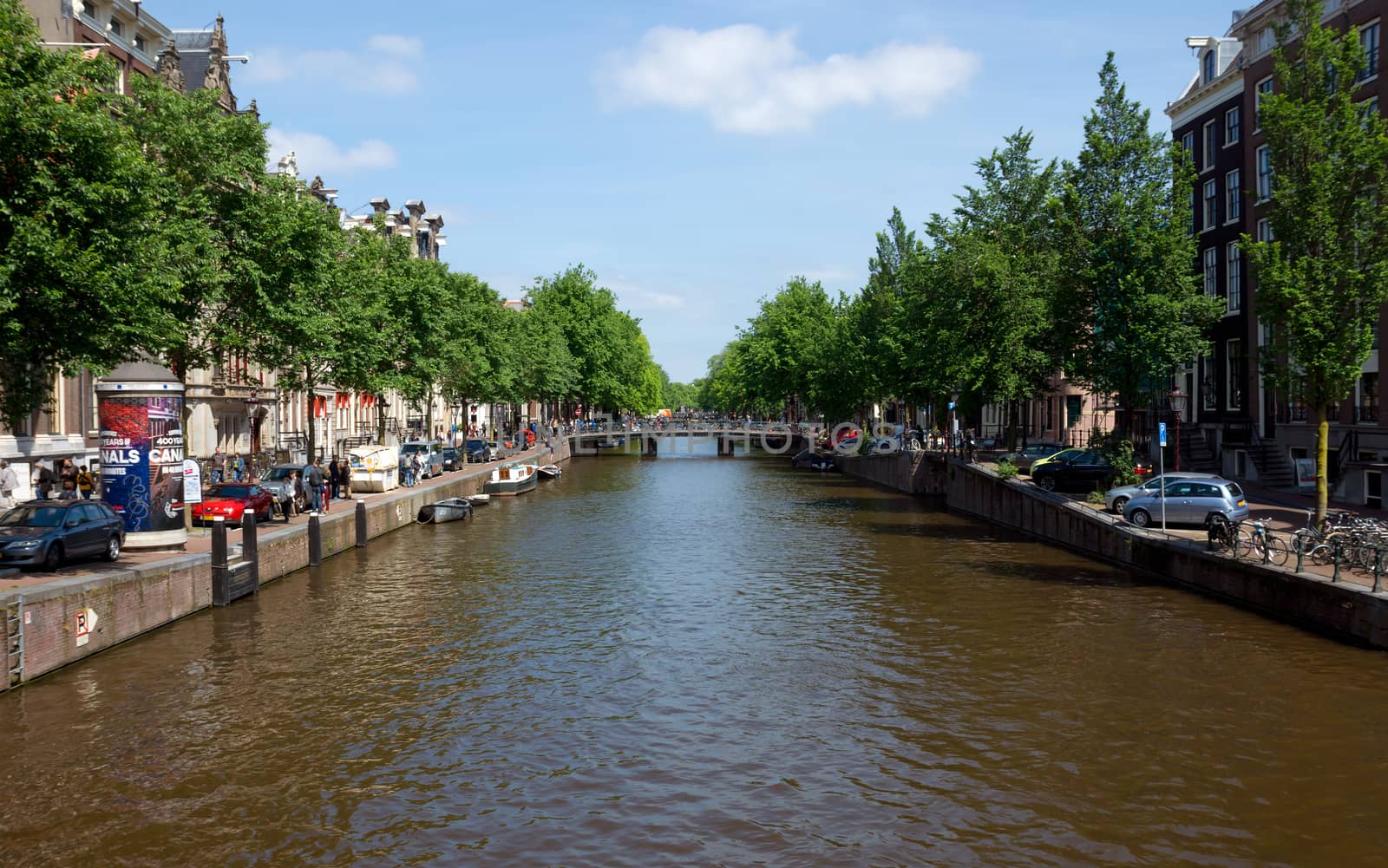 AMSTERDAM, NETHERLANDS - MAY 30: Amsterdam canals on May 30, 2014 in Amsterdam, Netherlands. View of Amsterdam canals and typical dutch houses.

Amsterdam, Netherlands - May 30, 2014: View of Amsterdam canals and typical dutch houses. People are walking by street.