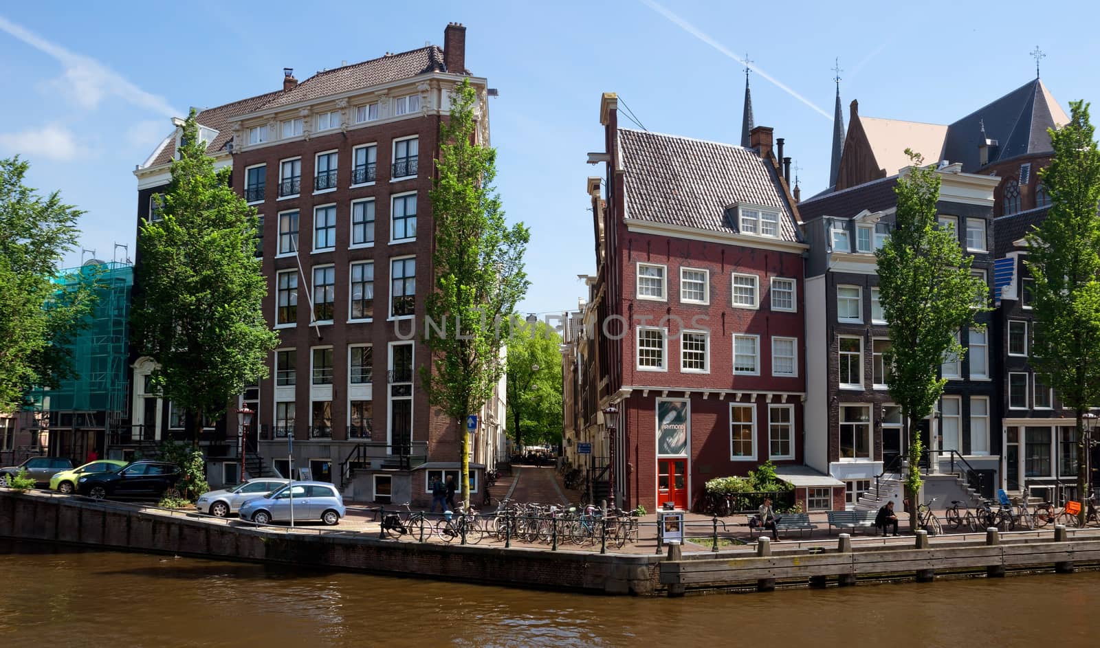AMSTERDAM, NETHERLANDS - MAY 30: Amsterdam canals on May 30, 2014 in Amsterdam, Netherlands. View of Amsterdam canals and typical dutch houses.

Amsterdam, Netherlands - May 30, 2014: View of Amsterdam canals and typical dutch houses. People are resting on the street.