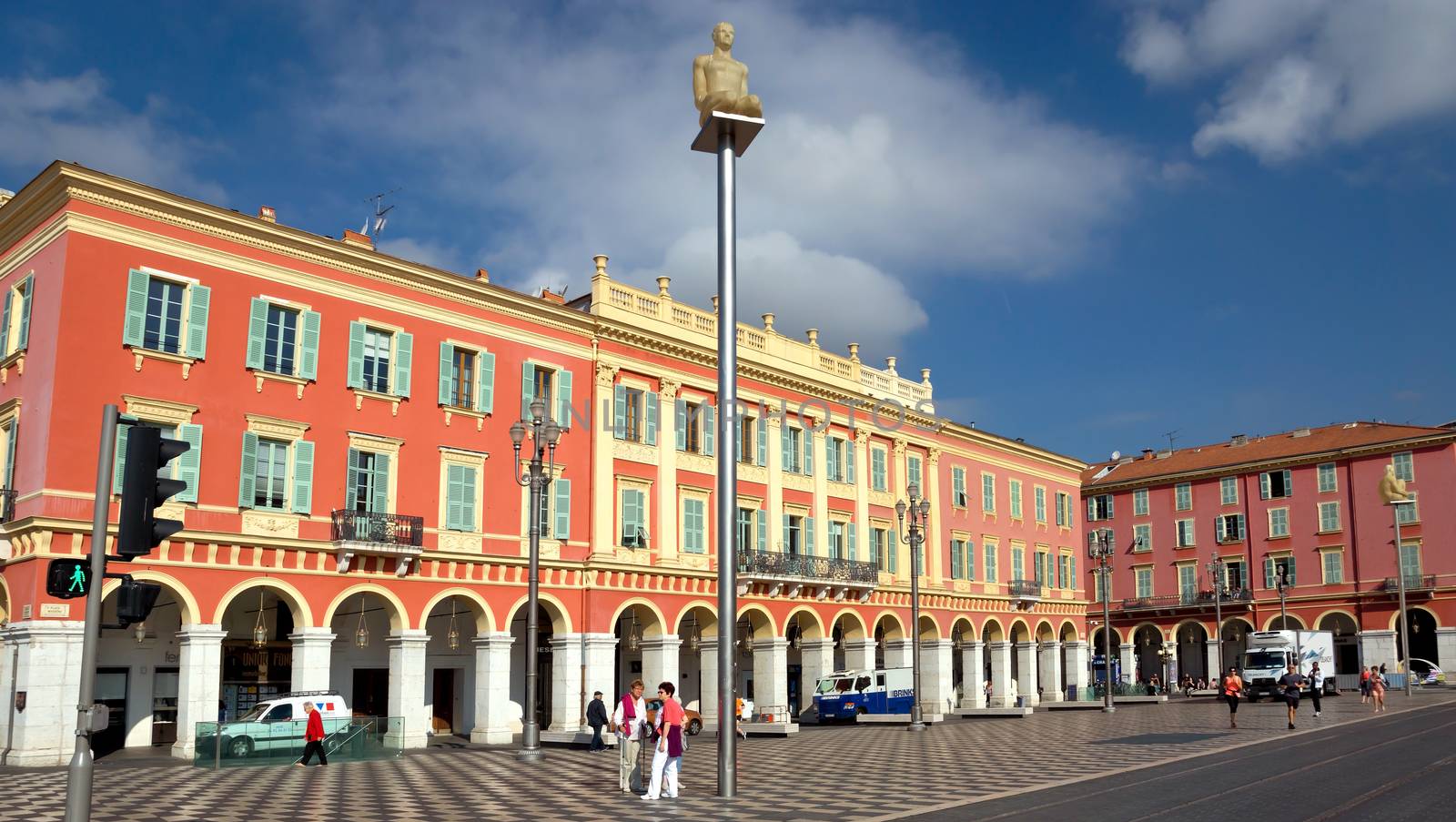 NICE, FRANCE - MAY 31: Architecture of the Place Massena on May 31, 2014 in Nice, France. Square is located in the city center and is the most popular destination among tourists. The square was reconstructed in 1979.

Nice, France - May 31, 2014: Architecture of the Place Massena. Square is located in the city center and is the most popular destination among tourists. The square was reconstructed in 1979. The seven figures designed by Jaume Plensa for Place Massena represent the different continents. At night, soft variations in colour symbolize the dialogue between the communities making up our society. They invite passers-by to look up and rediscover the sky of Nice. There are many boutiques, cafes and restaurants. People are walking by square.