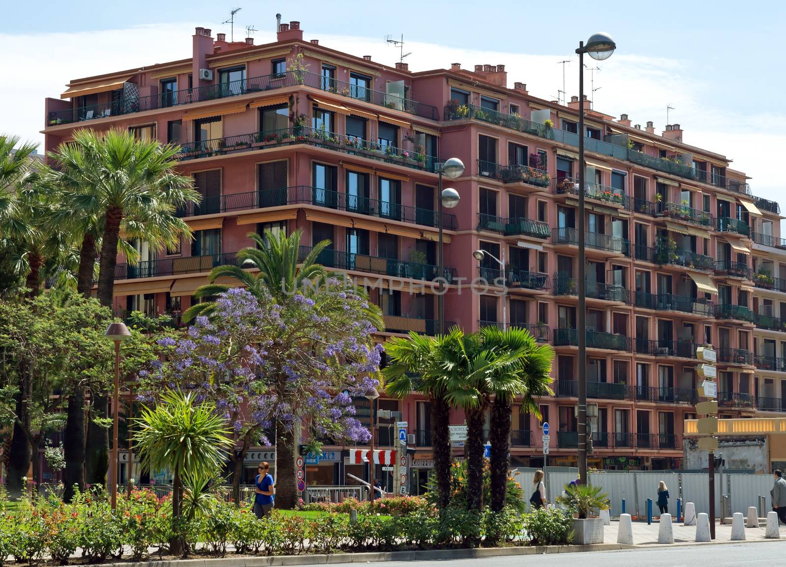 NICE, FRANCE - JUNE 4, 2014: Architecture along Promenade des Anglais. Promenade des Anglais is a symbol of the Cote d'Azur and was built in 1830 at the expense of the British colony.

Nice, France - June 4, 2014: Architecture along Promenade des Anglais. Promenade des Anglais is a symbol of the Cote d'Azur and was built in 1830 at the expense of the British colony. People are walking by street.