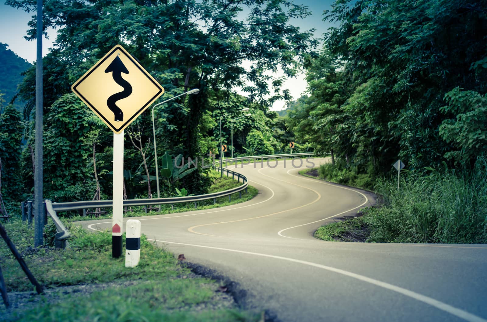 Snake curved road and warning sign by Kankliang