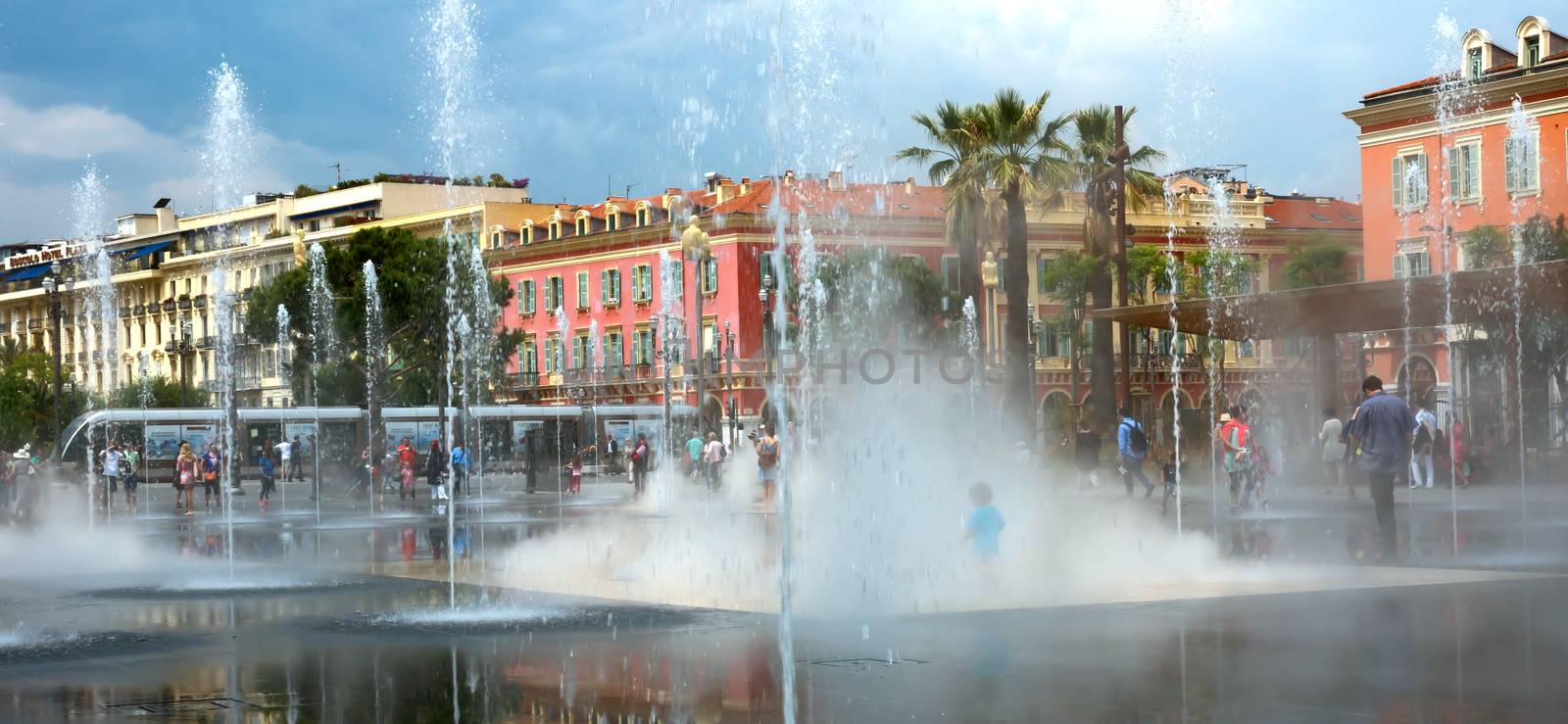 NICE, FRANCE - JUNE 4, 2014: Lovely fountain on Place Massena in Nice. Place Massena is Main Square of the city and it is used for concerts and other events which take place in the city.

Nice, France - June 4, 2014: Lovely fountain on Place Massena in Nice. Place Massena is Main Square of the city and it is used for concerts and other events which take place in the city. People are walking inside and outside of the fountain.