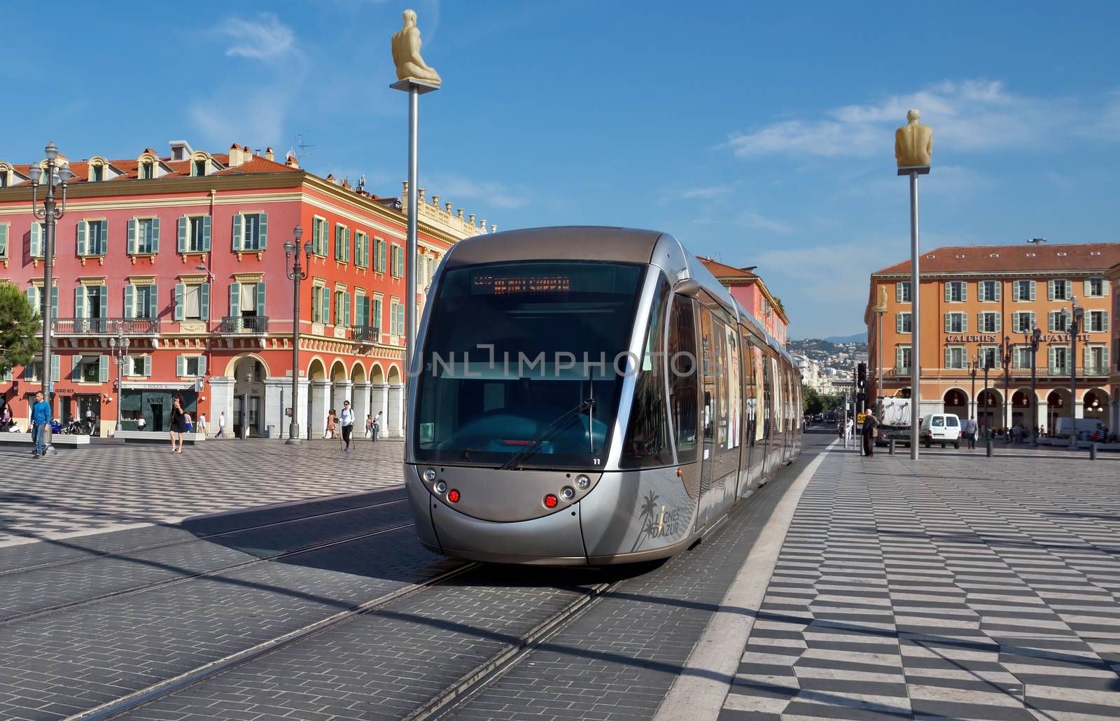 NICE, FRANCE - JUNE 6, 2014: Modern tram in the center of Nice, France. The square was reconstructed in 1979.

Nice, France - June 6, 2014: Modern tram in the center of Nice, France. The square was reconstructed in 1979. People are walking by square.