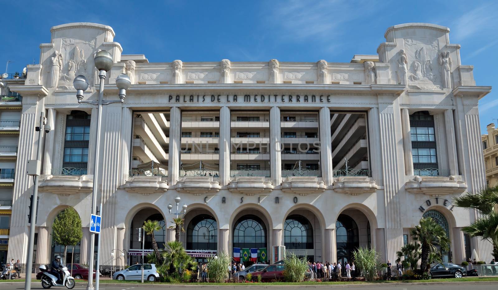 NICE, FRANCE - JUNE 6, 2014: Mediterranean Palace is located on the Promenade des Anglais. This hotel was built in 1930 by architect Charles Dalma.

Nice, France - June 6, 2014: Mediterranean Palace is located on the Promenade des Anglais. This hotel was built in 1930 by architect Charles Dalma. People are standing near hotel.
