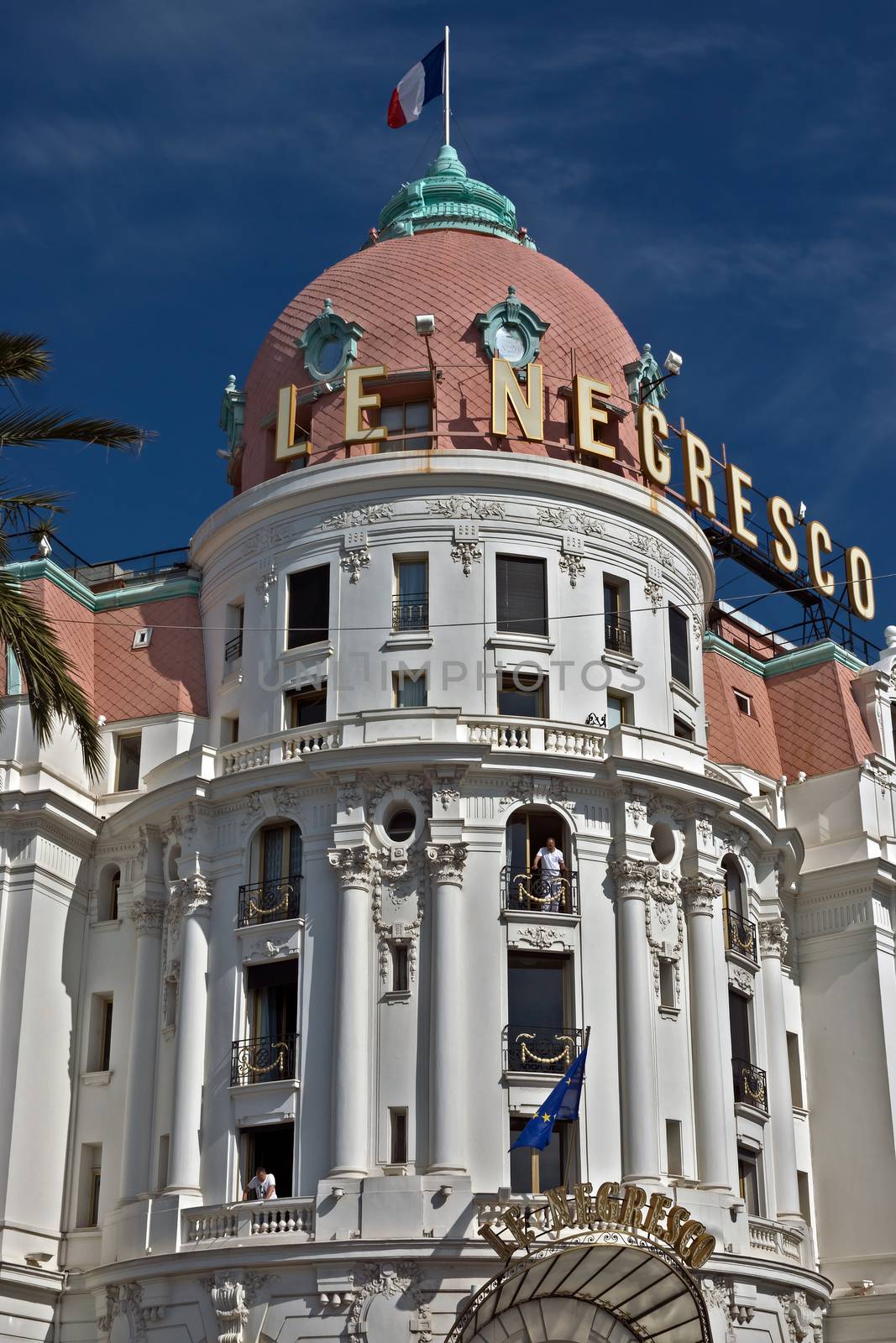NICE, FRANCE - JUNE 6, 2014: Luxury Hotel Negresco on English Promenade in Nice, French Riviera. Hotel Negresco is the famous luxury hotel on the Promenade des Anglais in Nice.

Nice, France - June 6, 2014: Luxury Hotel Negresco on English Promenade in Nice, French Riviera. Hotel Negresco is the famous luxury hotel on the Promenade des Anglais in Nice, a symbol of the Cote d'Azur. People are standing near the hotel and are on the balconies.