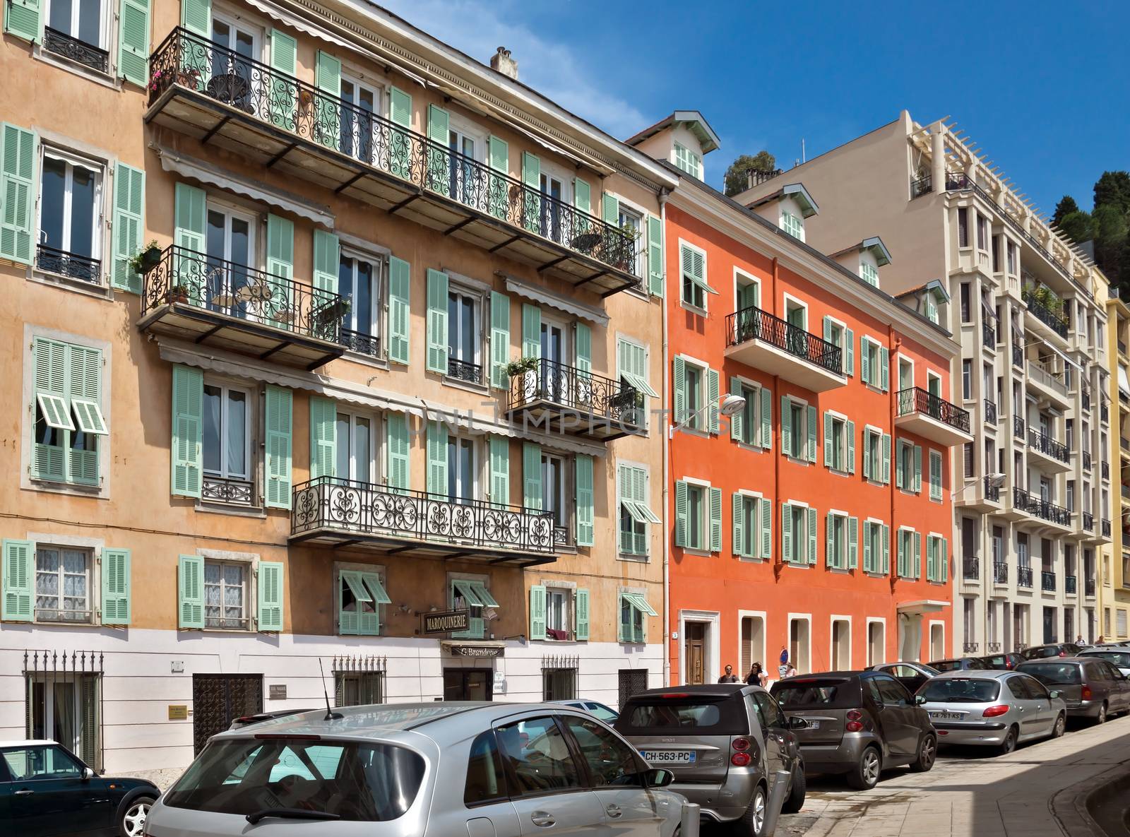 NICE, FRANCE - JUNE 6, 2014: Architecture along Promenade des Anglais. Promenade des Anglais is a symbol of the Cote d'Azur and was built in 1830 at the expense of the British colony.

Nice, France - June 6, 2014: Architecture along Promenade des Anglais. Promenade des Anglais is a symbol of the Cote d'Azur and was built in 1830 at the expense of the British colony. People are walking by street.