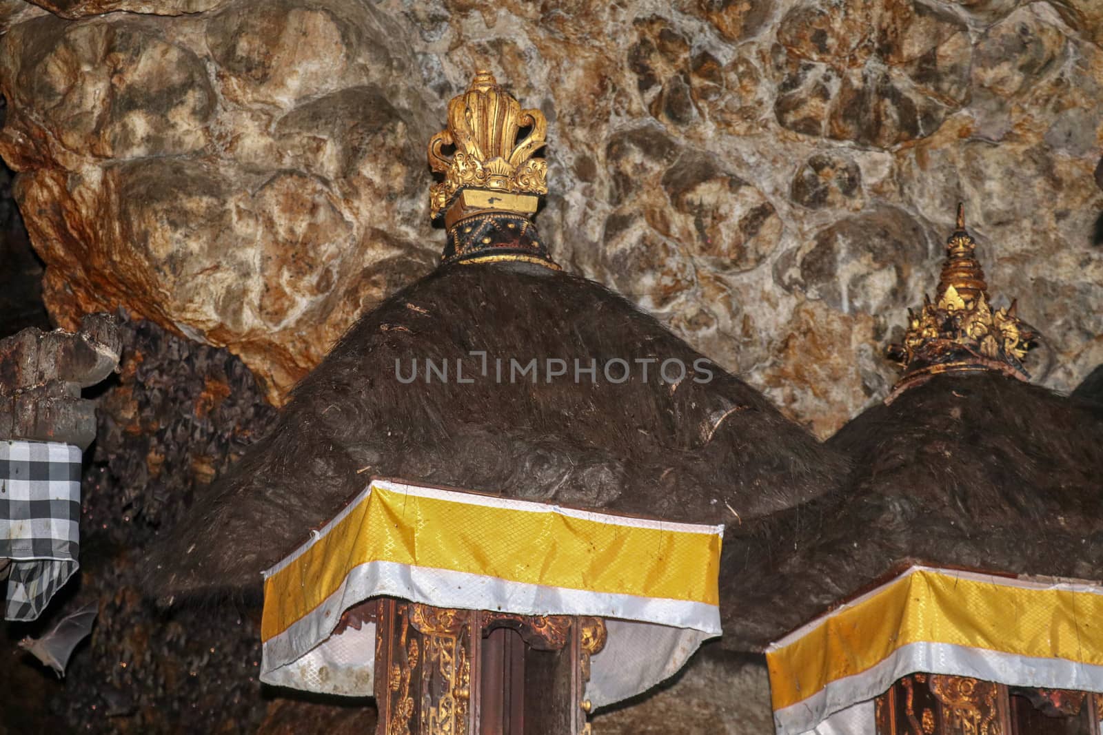 Altars at Pura Goa Lawah or Bat Cave Temple. Balinese Hindu temple in Pesinggahan, Klungkung, Bali, Indonesia. Many bats hanging from the ceiling of the Cave of bats. Colony of bats are waiting dark.