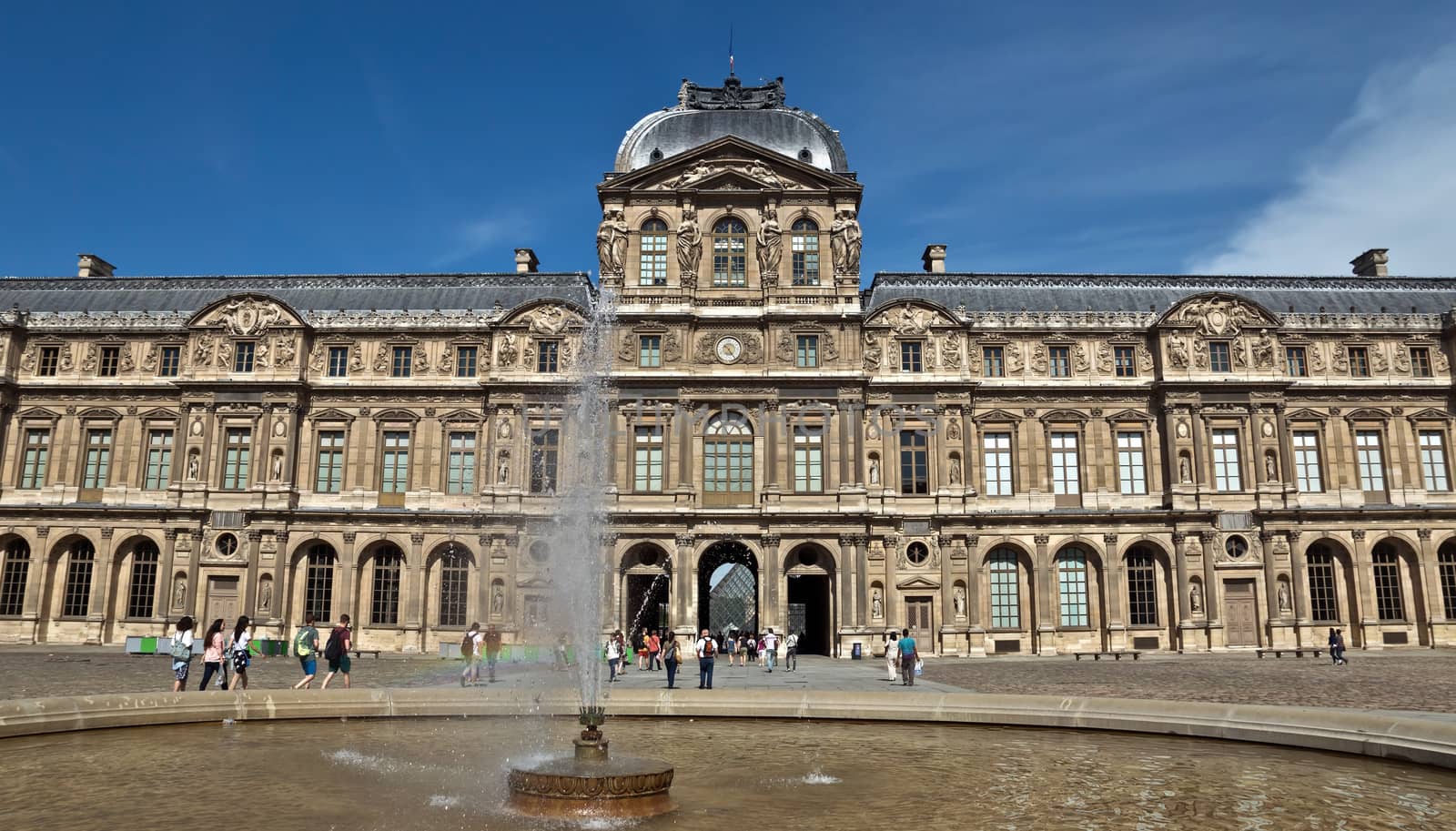 PARIS, FRANCE - JUNE 9, 2014: The Louvre Museum. Louvre is one of the biggest Museum in the world, receiving more than 8 million visitors each year.

Paris, France - June 9, 2014: The Louvre Museum. Louvre is one of the biggest Museum in the world, receiving more than 8 million visitors each year. People are walking near the museum.