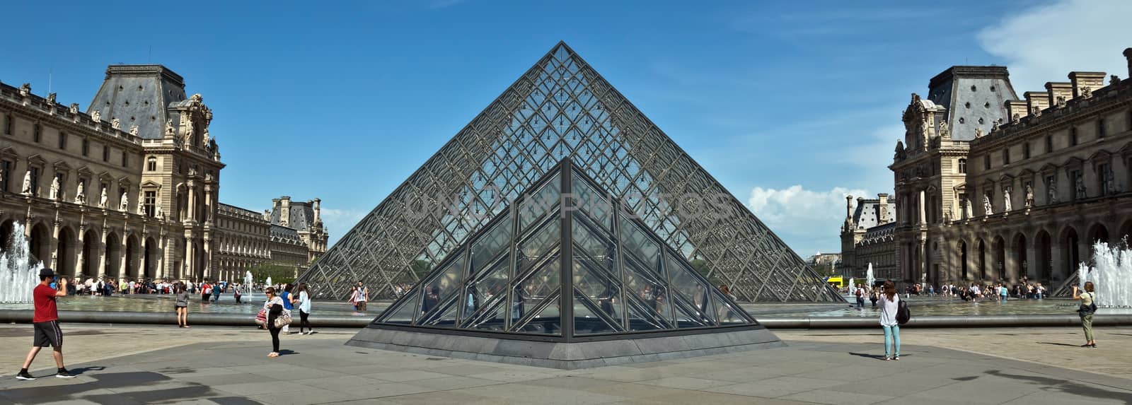 PARIS, FRANCE - JUNE 9: Pyramid near Louvre Museum. Louvre is one of the biggest Museum in the world, receiving more than 8 million visitors each year.

Paris, France - June 9, 2014: Pyramid near Louvre Museum. Louvre is one of the biggest Museum in the world, receiving more than 8 million visitors each year. People are walking near pyramid.