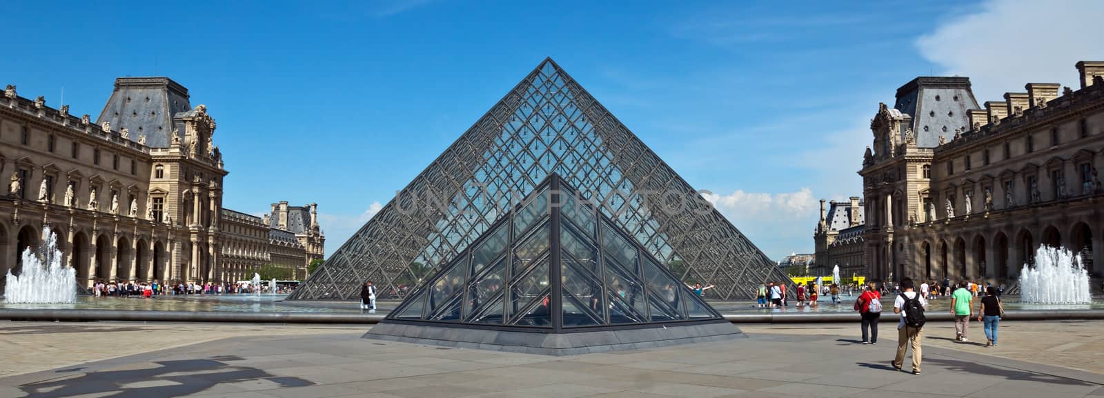 PARIS, FRANCE - JUNE 9, 2014: Pyramid near Louvre Museum. Louvre is one of the biggest Museum in the world, receiving more than 8 million visitors each year.

Paris, France - June 9, 2014: Pyramid near Louvre Museum. Louvre is one of the biggest Museum in the world, receiving more than 8 million visitors each year. People are walking near with pyramid.