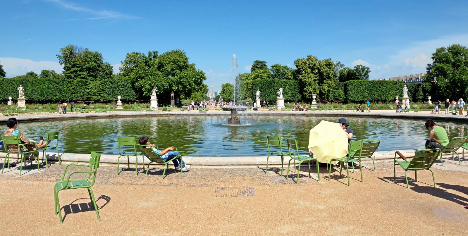 PARIS, FRANCE - JUNE 9: Tourist in famous Tuileries garden on June 9, 2014 in Paris, France. Tuileries Garden (Jardin des Tuileries) is a public garden located between the Louvre Museum and the Place de la Concorde.

Paris, France - June 9, 2014: Tourist in famous Tuileries garden. Tuileries Garden (Jardin des Tuileries) is a public garden located between the Louvre Museum and the Place de la Concorde. People are resting.
