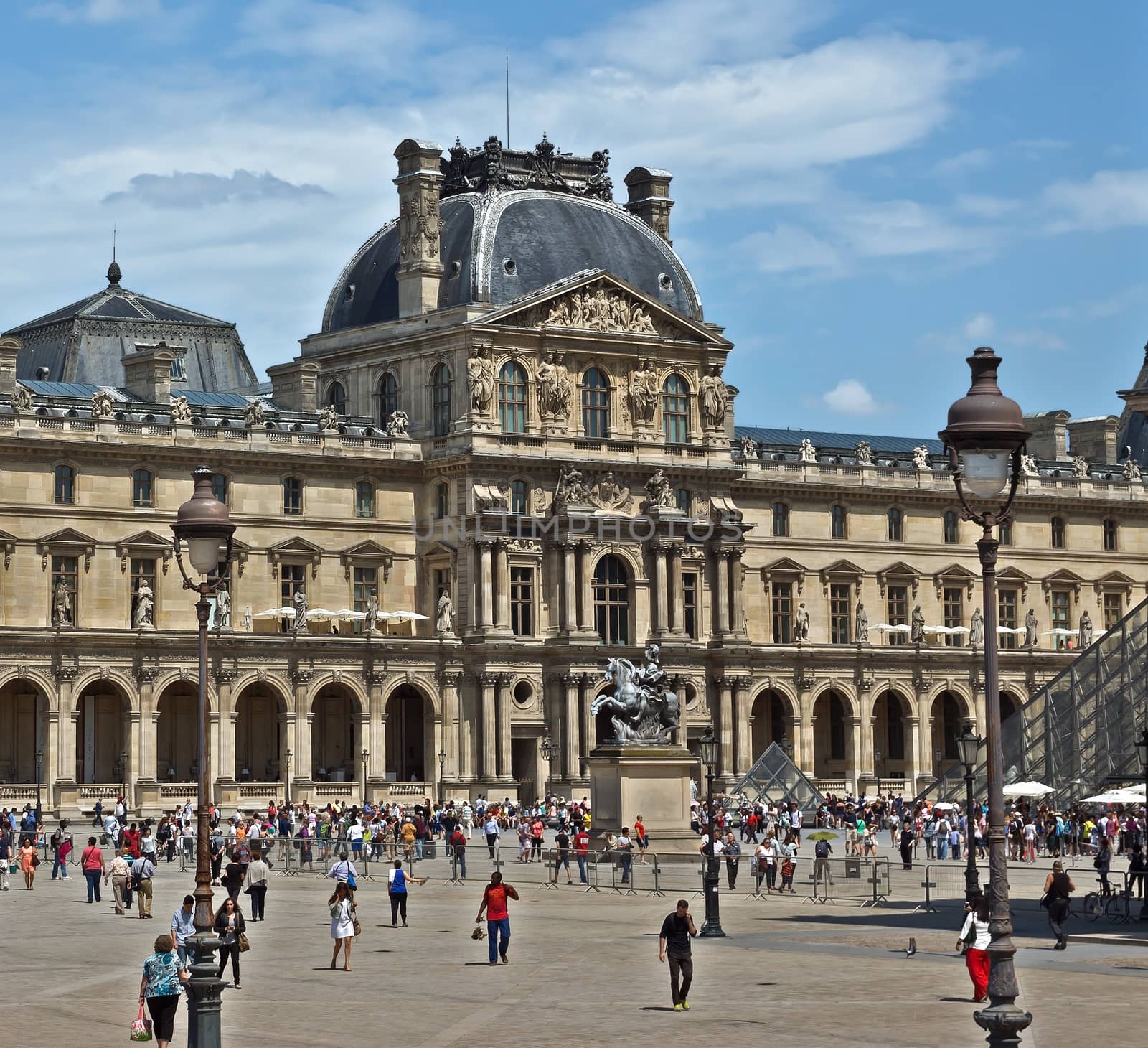 PARIS, FRANCE - JUNE 11, 2014: Louvre Museum. Louvre is one of the biggest Museum in the world, receiving more than 8 million visitors each year.

Paris, France - June 11, 2014: Louvre Museum. Louvre is one of the biggest Museum in the world, receiving more than 8 million visitors each year. People are walking by square.