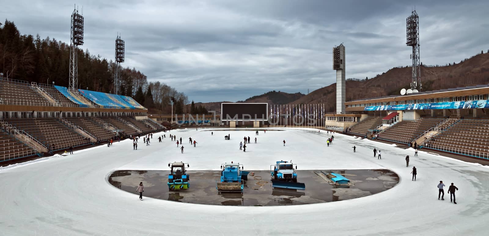 ALMATY, KAZAKHSTAN - NOVEMBER 4, 2014: View of Medeo outdoor stadium. Medeo is located on 1691 meters above sea level. 

Almaty, Kazakhstan - November 4, 2014: View of Medeo outdoor stadium. Medeo is located on 1691 meters above sea level. People are skating.