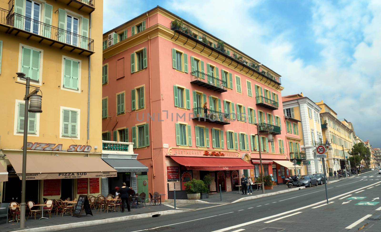 NICE, FRANCE - APRIL 27: Architecture along Promenade des Anglais on April 27, 2013 in Nice, France. It is a symbol of the Cote d'Azur and was built in 1830 at the expense of the British colony.

Nice, France - April 27, 2013: Architecture along Promenade des Anglais. People are walking. Promenade des Anglais is a symbol of the Cote d'Azur and was built in 1830 at the expense of the British colony.