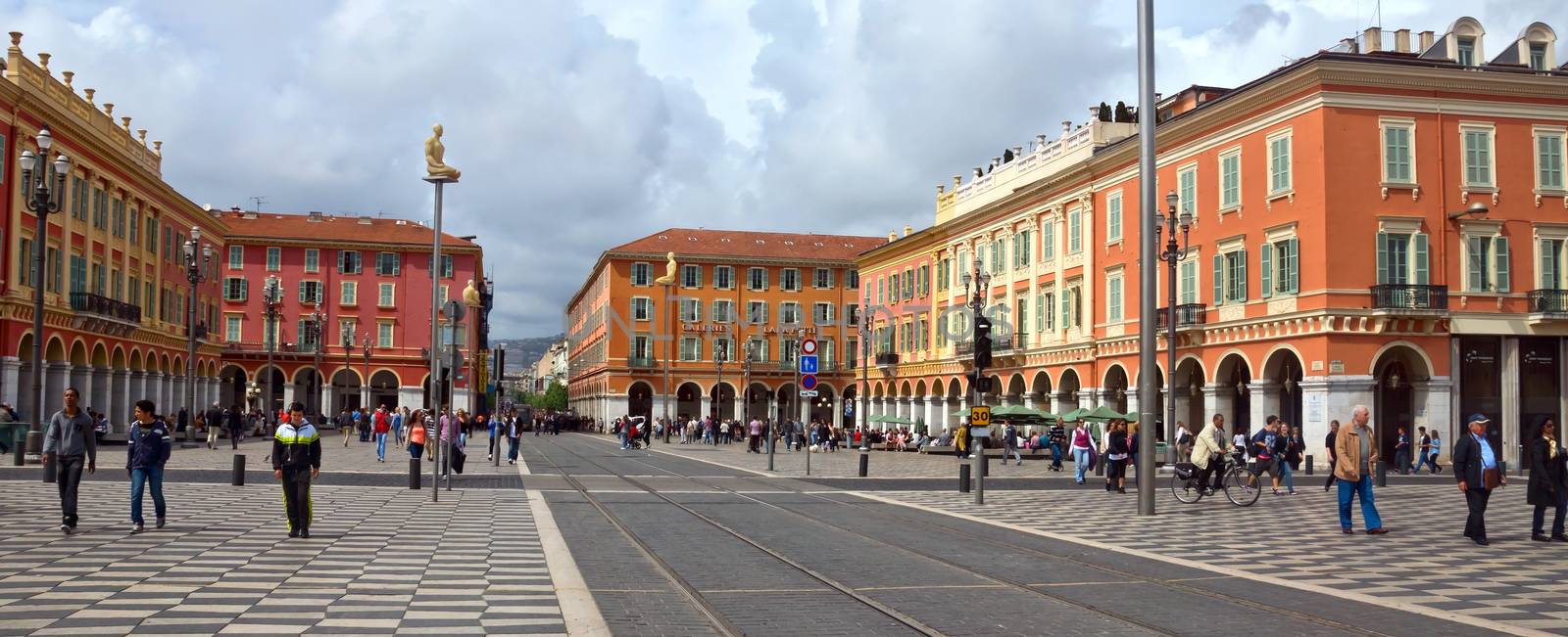 NICE, FRANCE - APRIL 27: The Place Massena on April 27, 2013 in Nice, France. The square was reconstructed in 1979.

Nice, France - April 27, 2013: Views of the Place Massena. Square is located in the city center and is the most popular destination among tourists. There are many boutiques, cafes and restaurants. People are walking thru scuare.